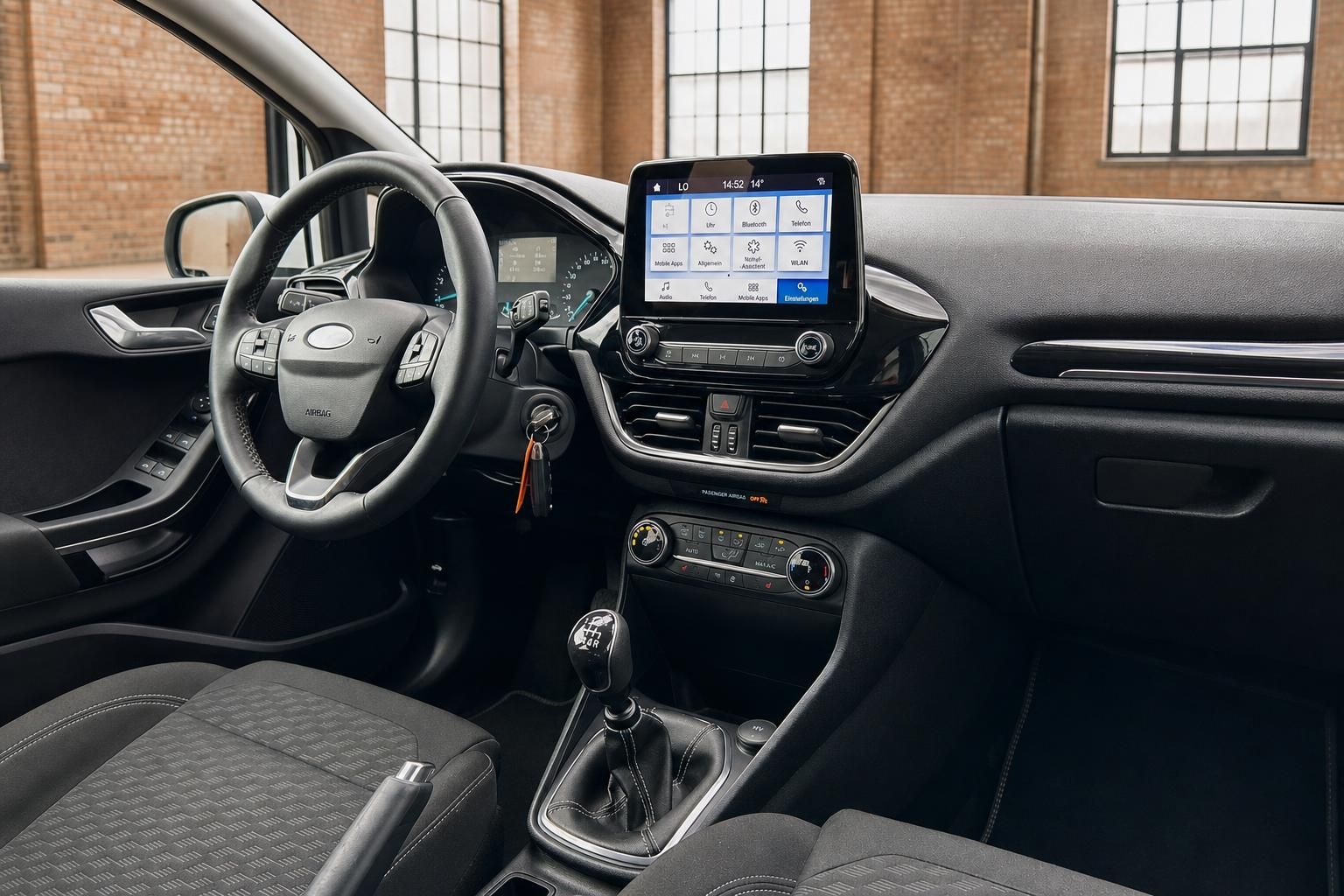 Ford Fiesta Innenraum mit Infotainment-Display, Lenkrad und Schaltgetriebe – Fahrerplatz