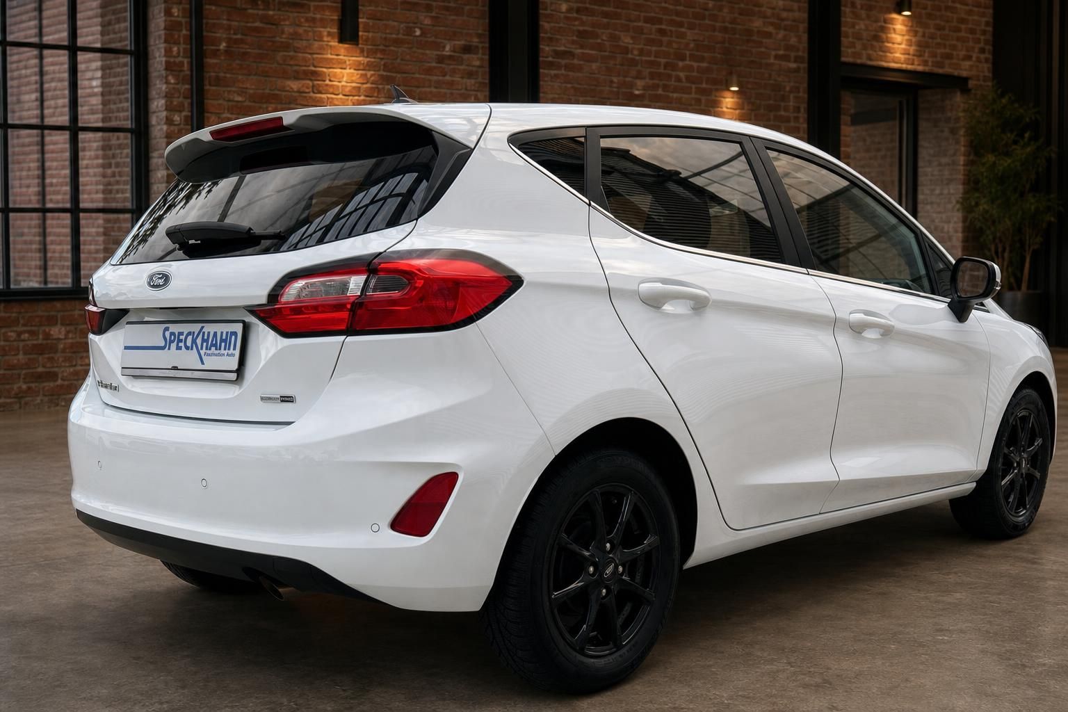 Ford Fiesta Hybrid weiss Heckansicht schräg rechts mit schwarzen Felgen und Spoiler im Aussenbereich