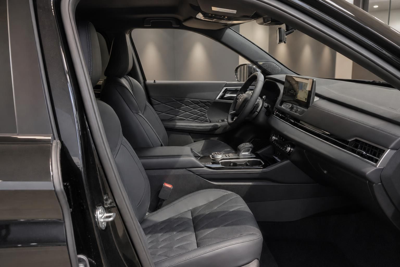 Vorderer Innenraum mit schwarzen Sitzen und Cockpit im Detail