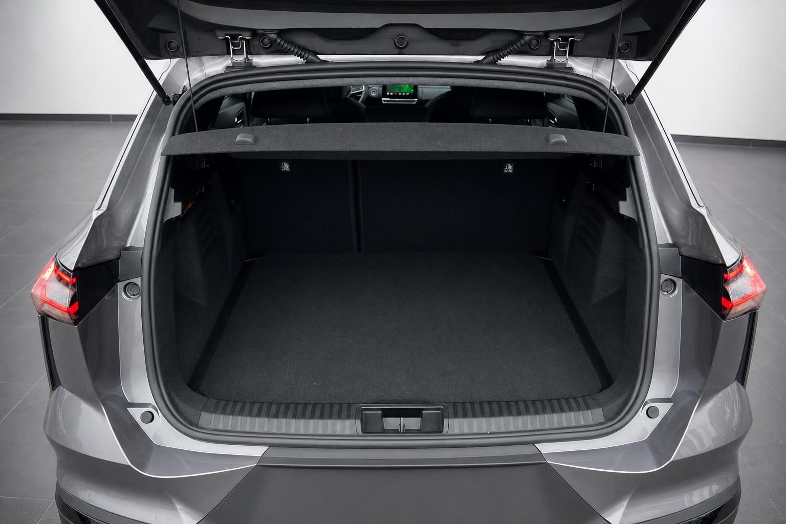 Geöffneter Kofferraum eines grauen SUV mit schwarzer Laderaumauskleidung und hochgeklappter Heckklappe