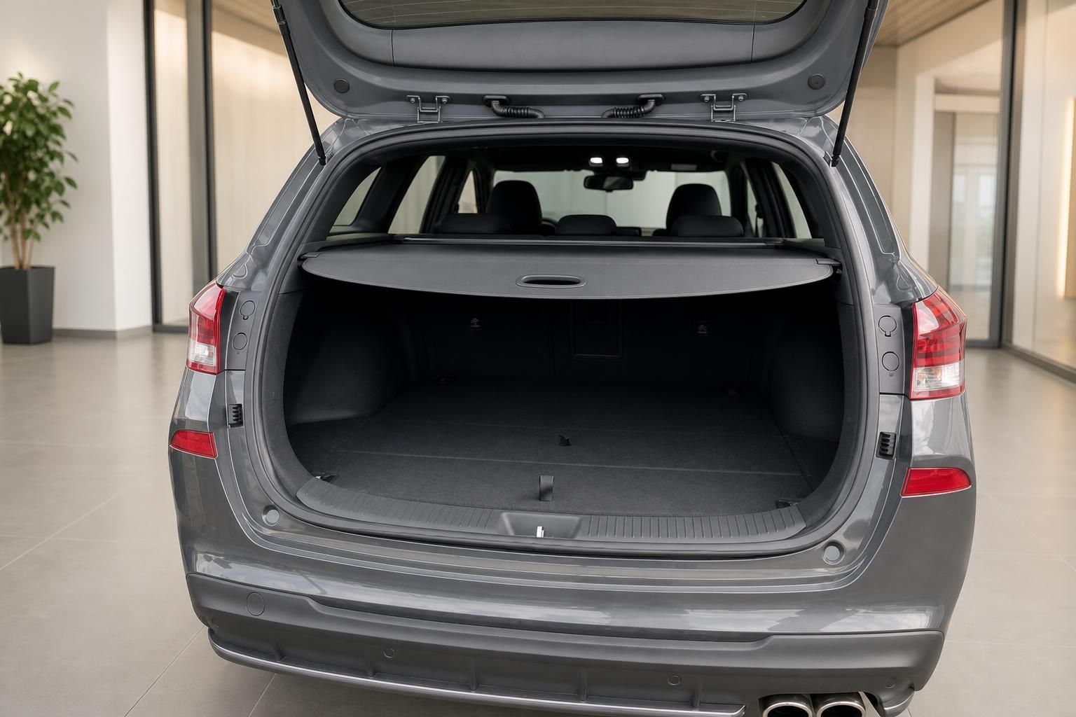 Kofferraum des grauen Hyundai Kombis mit geöffneter Heckklappe und Gepäckabdeckung