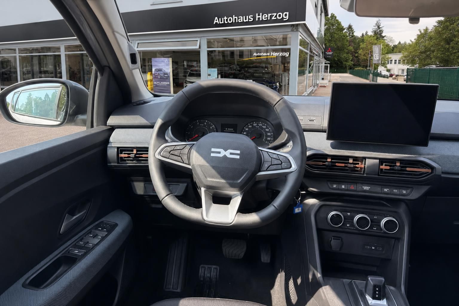 Cockpit mit Lenkrad und Multimedia-Display im Dacia bei Autohaus Herzog
