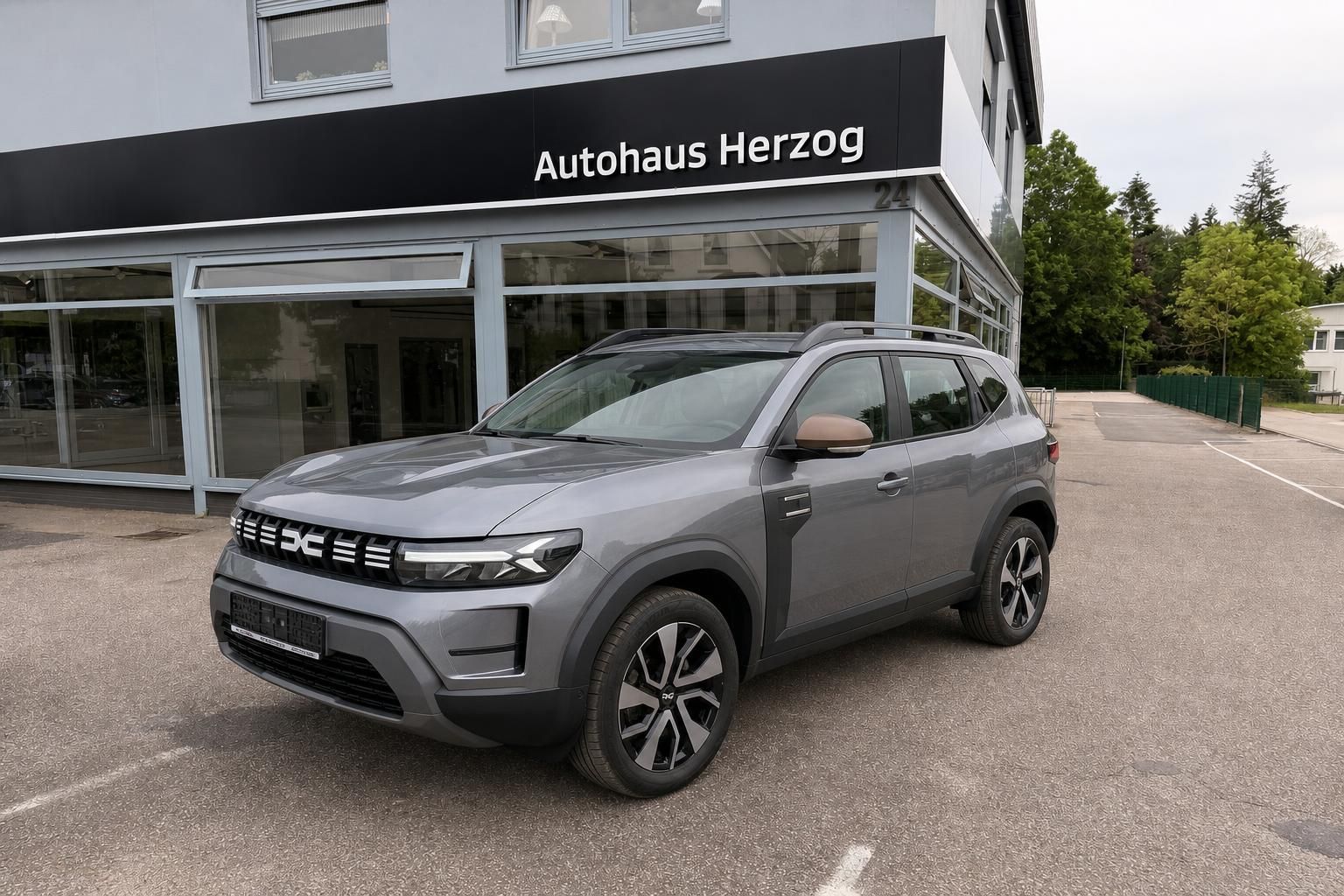 Dacia SUV in Grau von vorne seitlich vor Autohaus Herzog geparkt