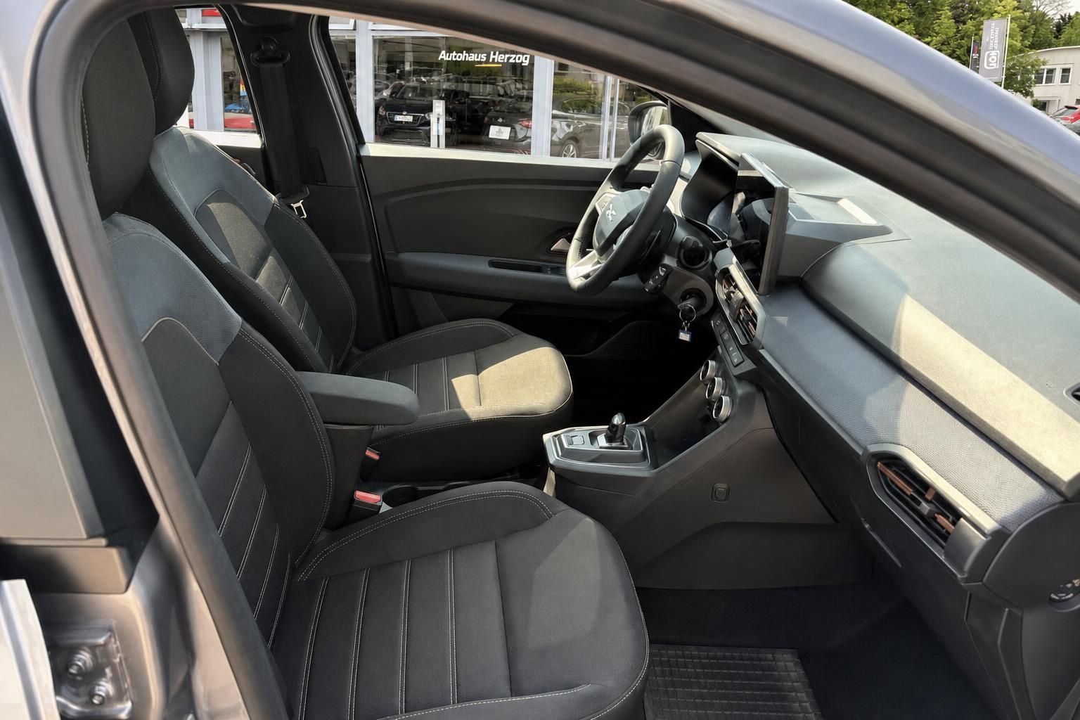 Blick ins Interieur eines Dacia mit Vordersitzen und Armaturenbrett