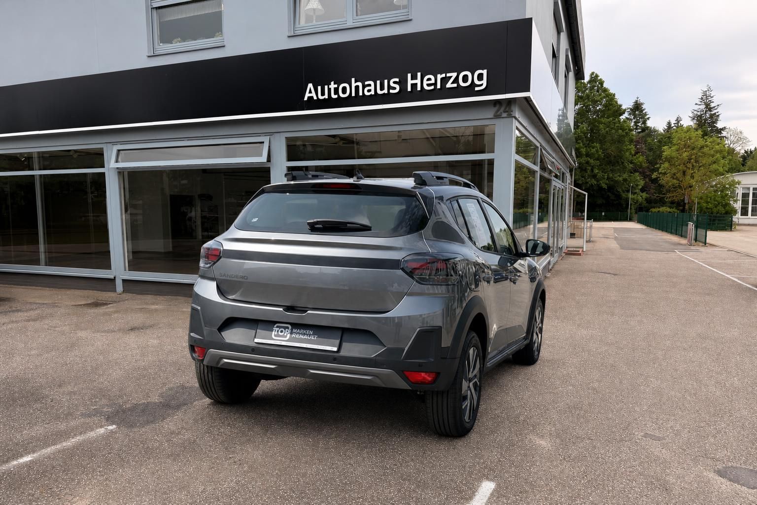Dacia Sandero grau Heckansicht auf Hof vor Autohaus Herzog