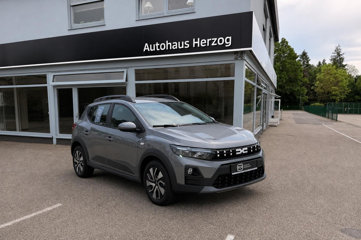Dacia Sandero Stepway grau, Seitenansicht vorne beim Autohaus
