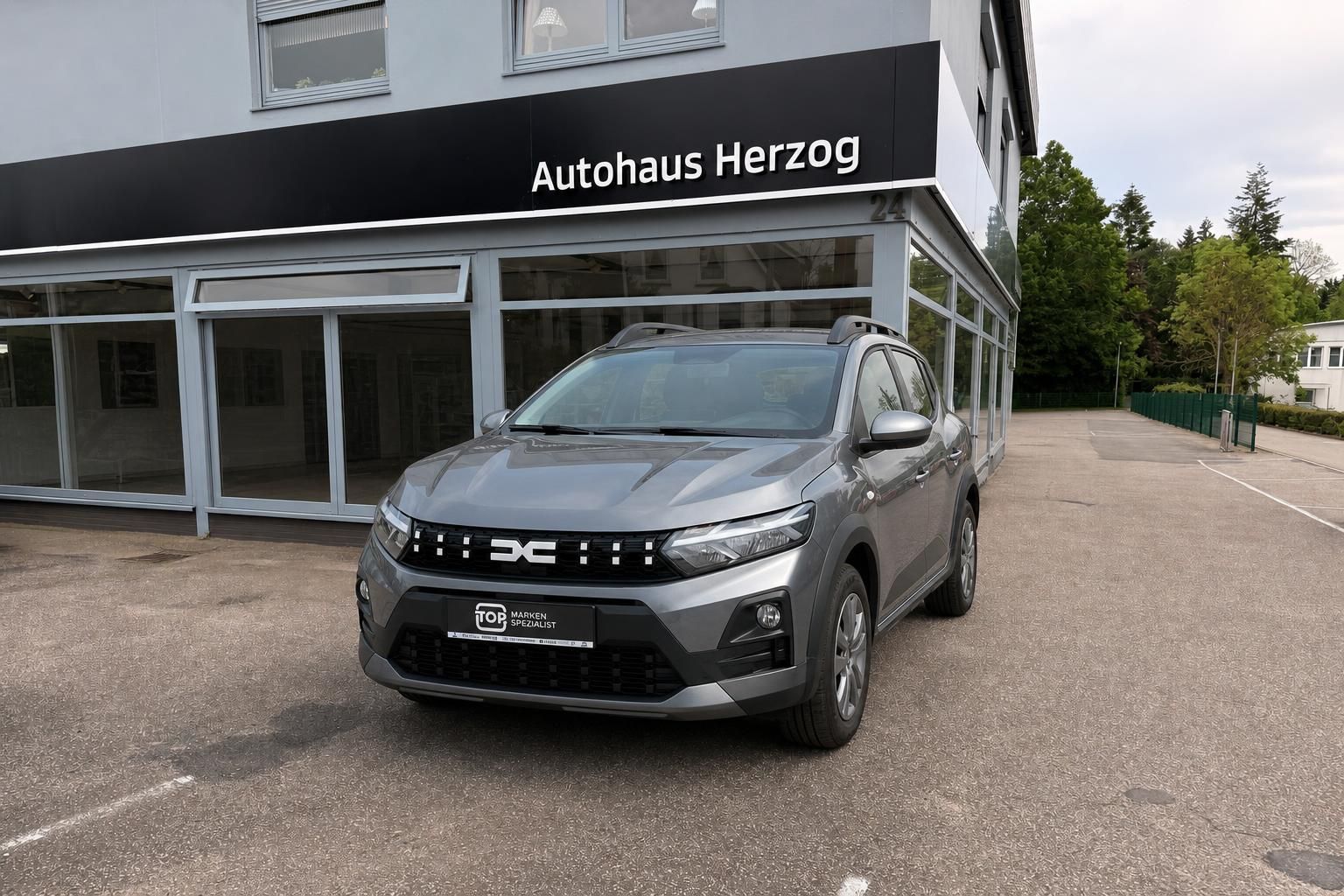 Dacia Sandero Stepway in Grau, Frontansicht vor Autohaus Herzog