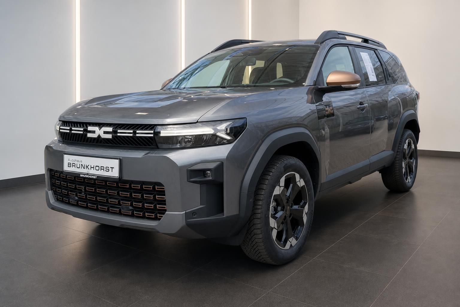 Grauer Dacia SUV Seitenansicht mit Allradfelgen und modernem Design