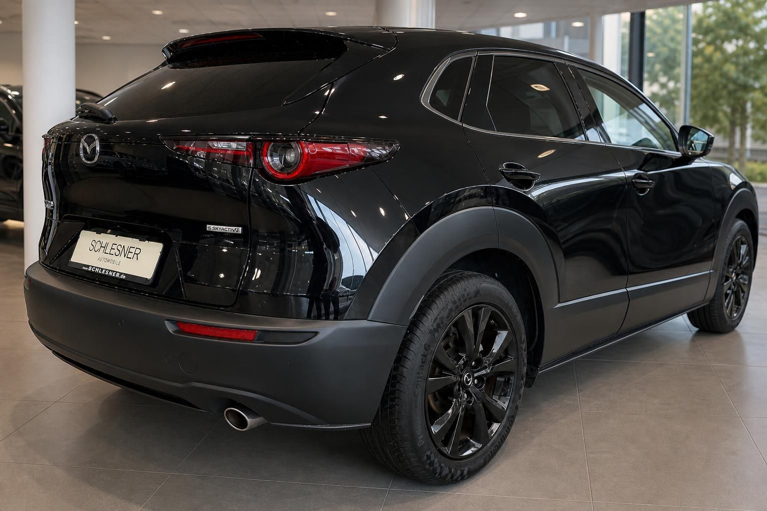 Mazda CX-30 in Schwarz, Heckansicht seitlich im Autohaus