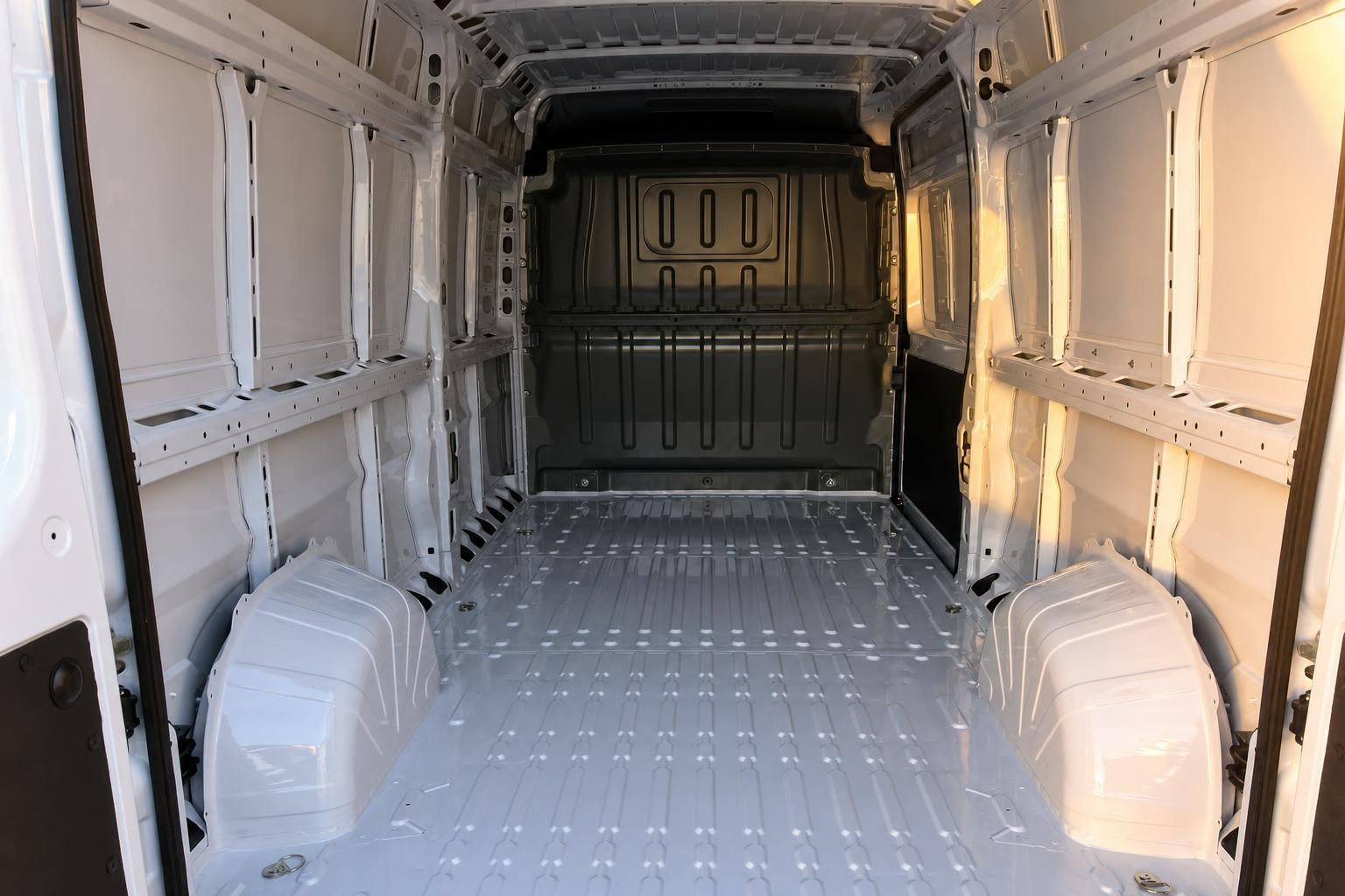 Laderaum eines Transporters mit weißem Metallboden und Trennwand zum Fahrerbereich