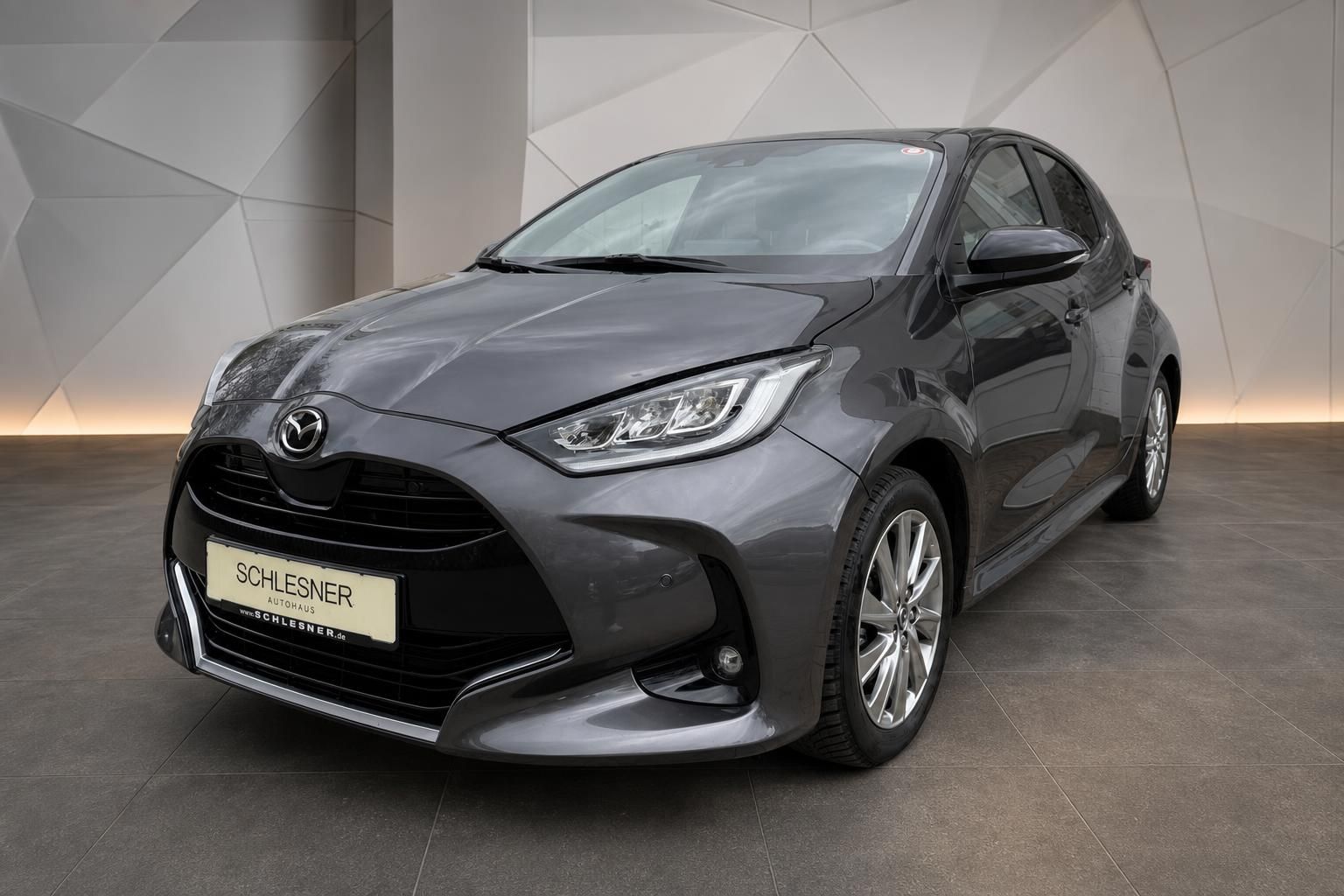 Mazda2 grau Frontansicht schraeg vor moderner Wand