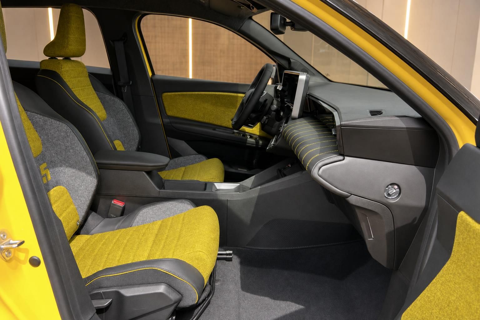 Renault 5 Innenraum – Vordersitze mit gelb-grauem Stoffbezug und Mittelkonsole von der Beifahrerseite