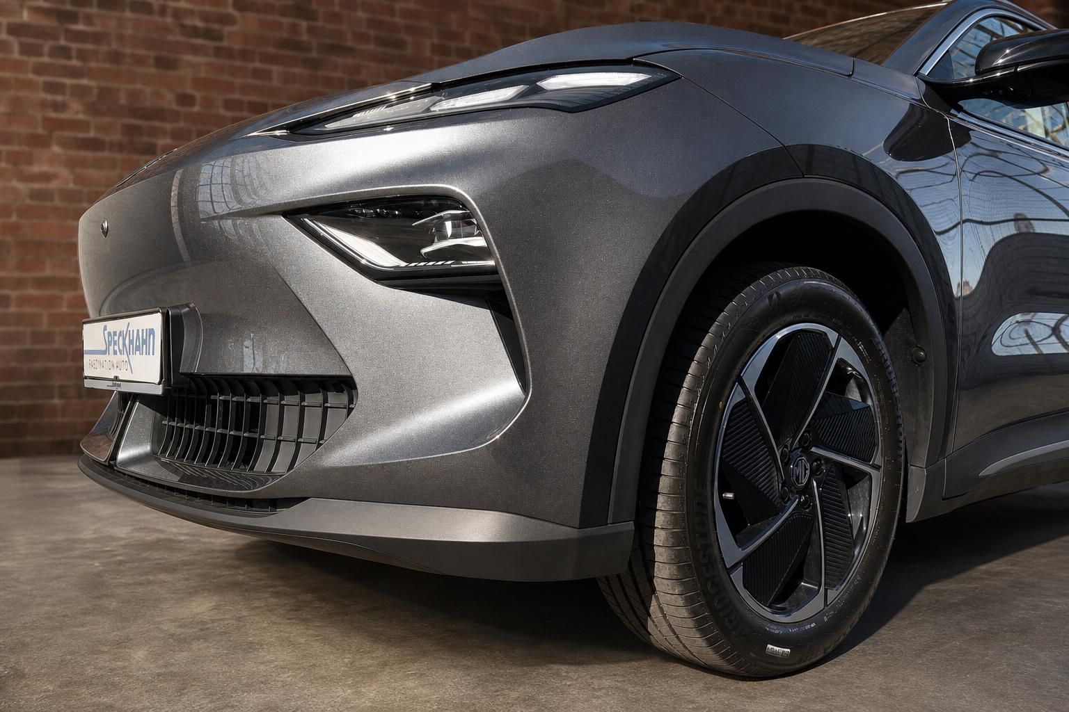 MG SUV Grau, Frontpartie mit Scheinwerfer und Felge im Detail