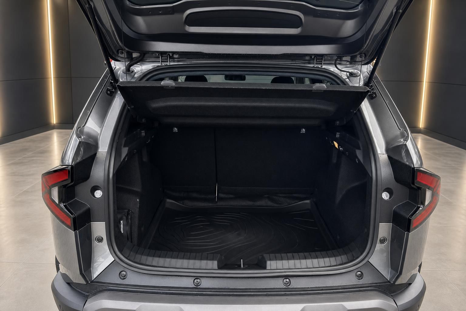 Offener Kofferraum eines grauen SUVs mit schwarzer Innenausstattung und Ladekabel
