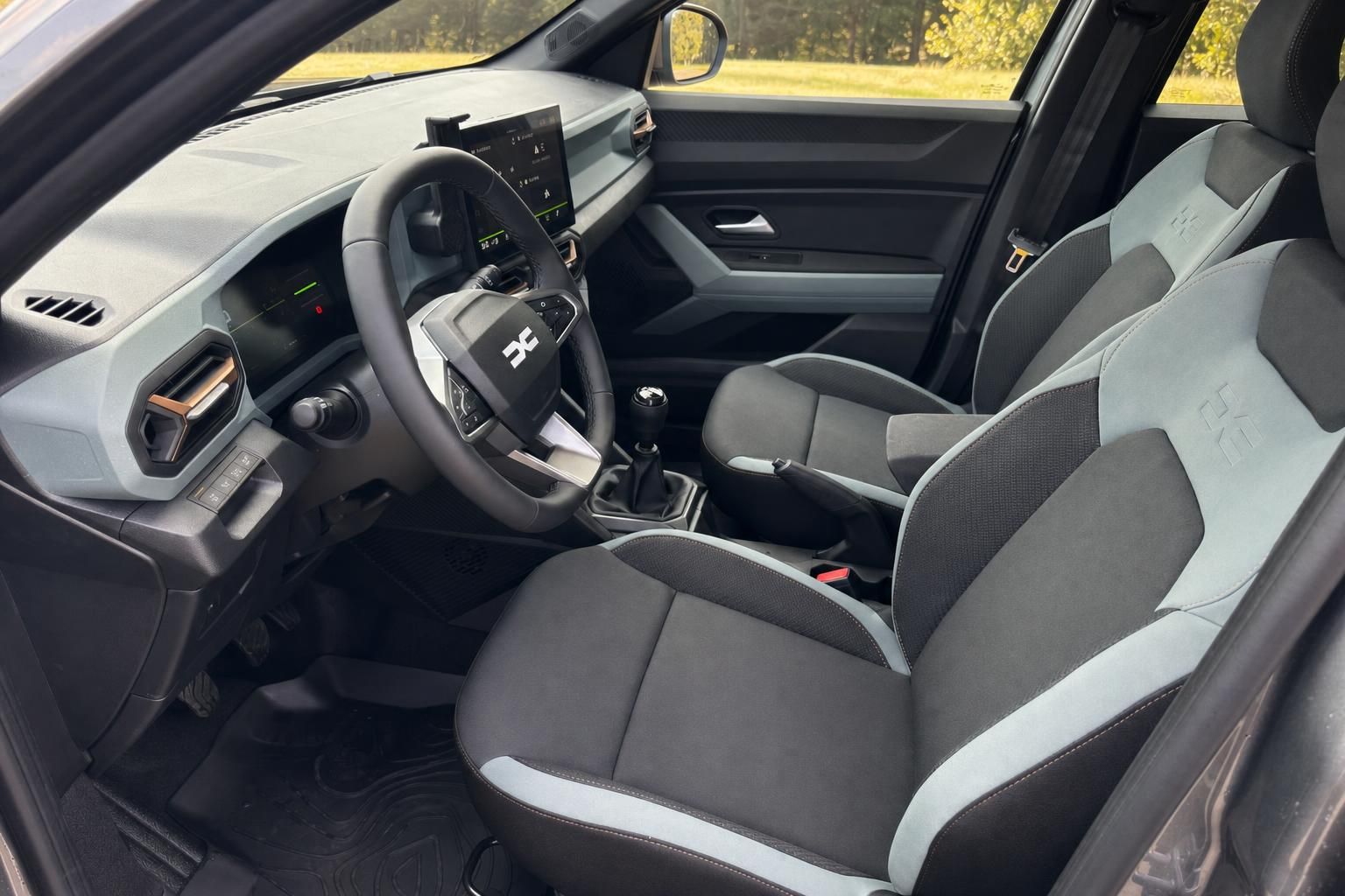 PKW Cockpit mit Lenkrad, Schalthebel und schwarz-grauen Sportsitzen