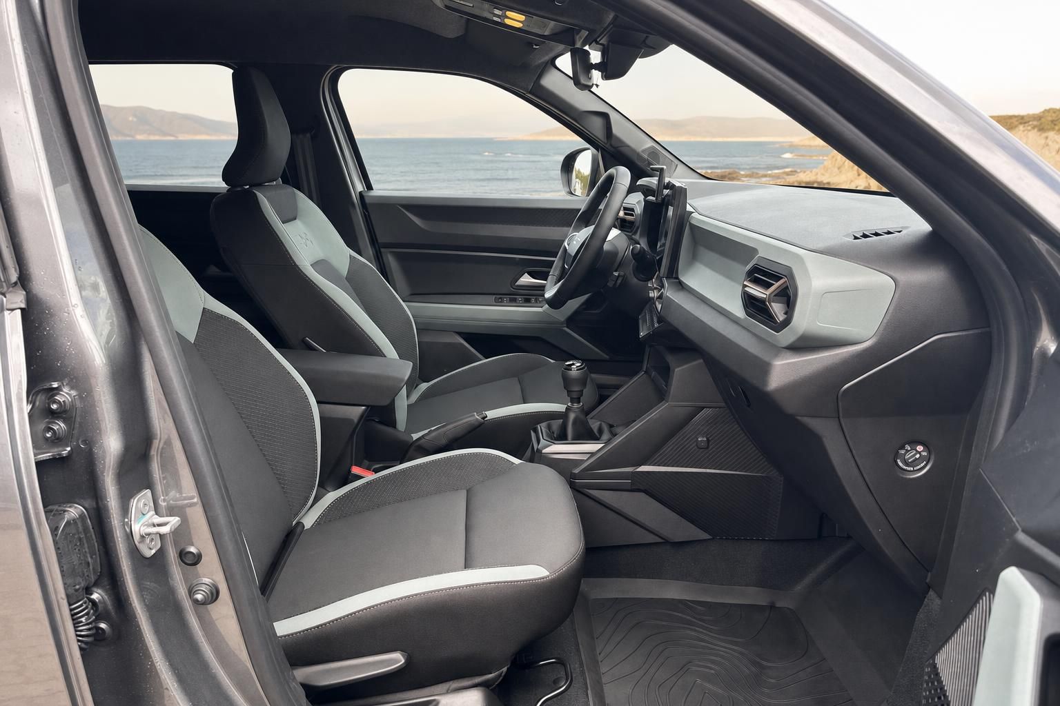 Auto Innenraum Fahrersitz mit Blick aufs Meer, schwarze Sitze und Armaturenbrett