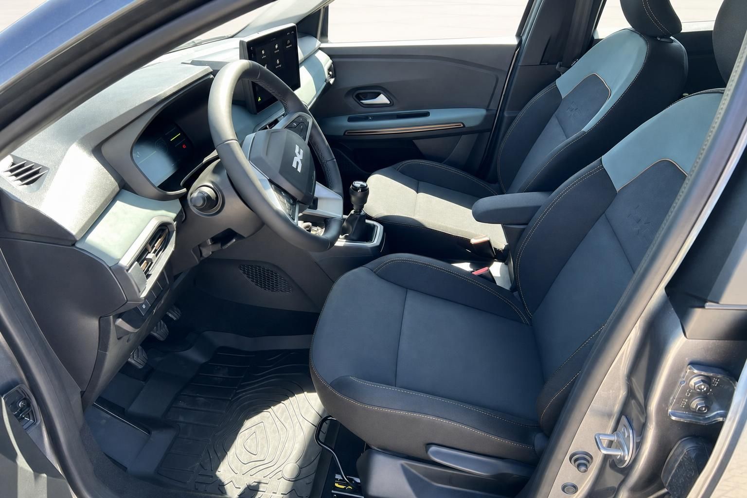 Dacia Sandero Innenraum vorne, schwarze Sitze mit Schaltgetriebe und modernes Cockpit Design