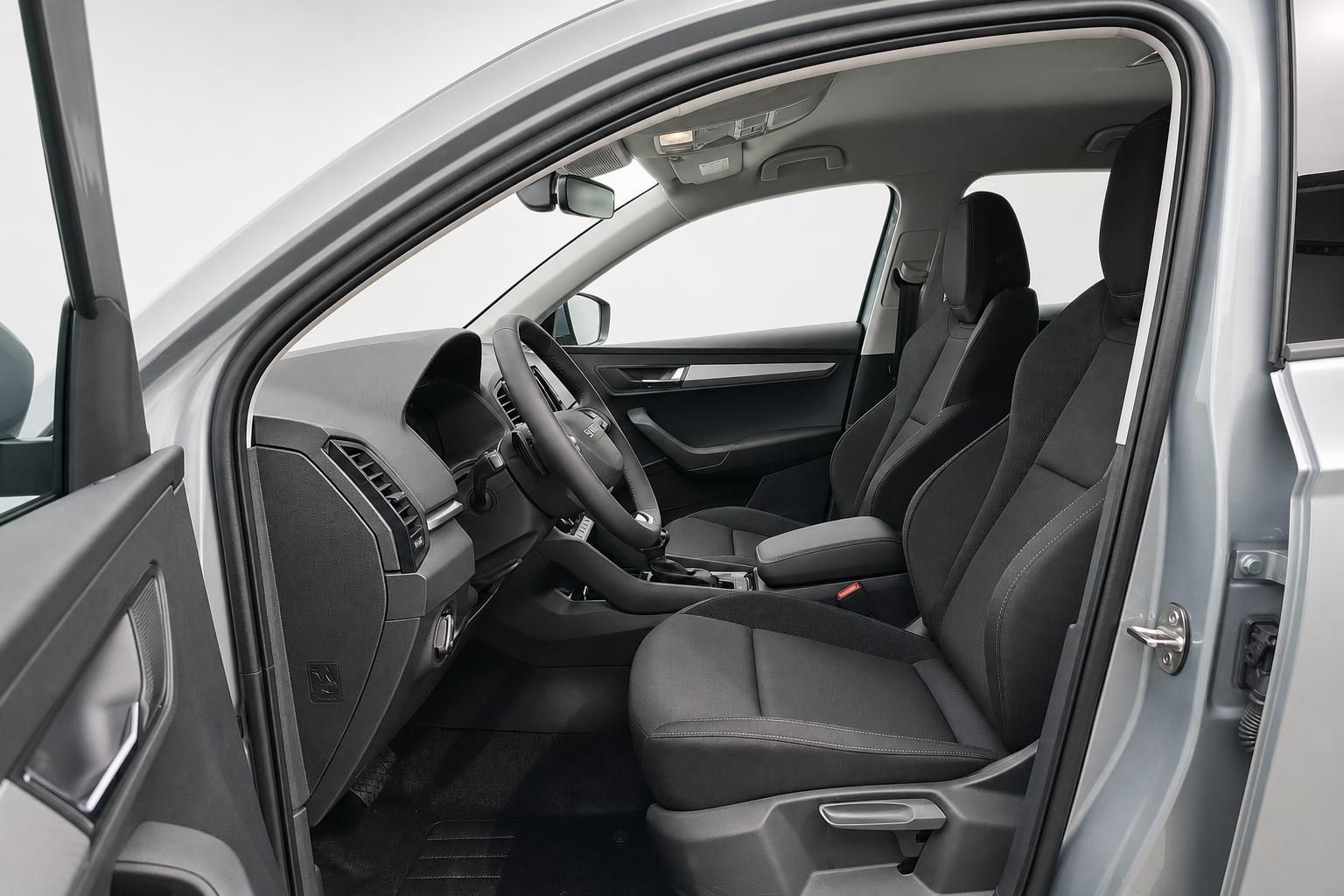 Skoda Karoq Innenraum mit Vordersitzen und Blick durch geoeffnete Tuer