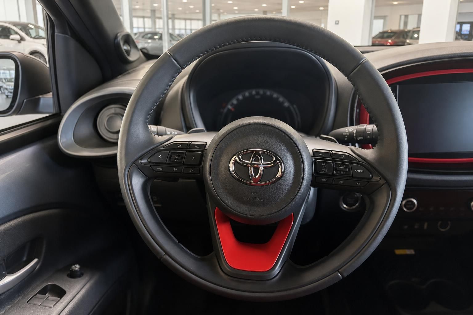 Toyota Aygo X Innenraum mit Lenkrad und rotem Akzent im Detail