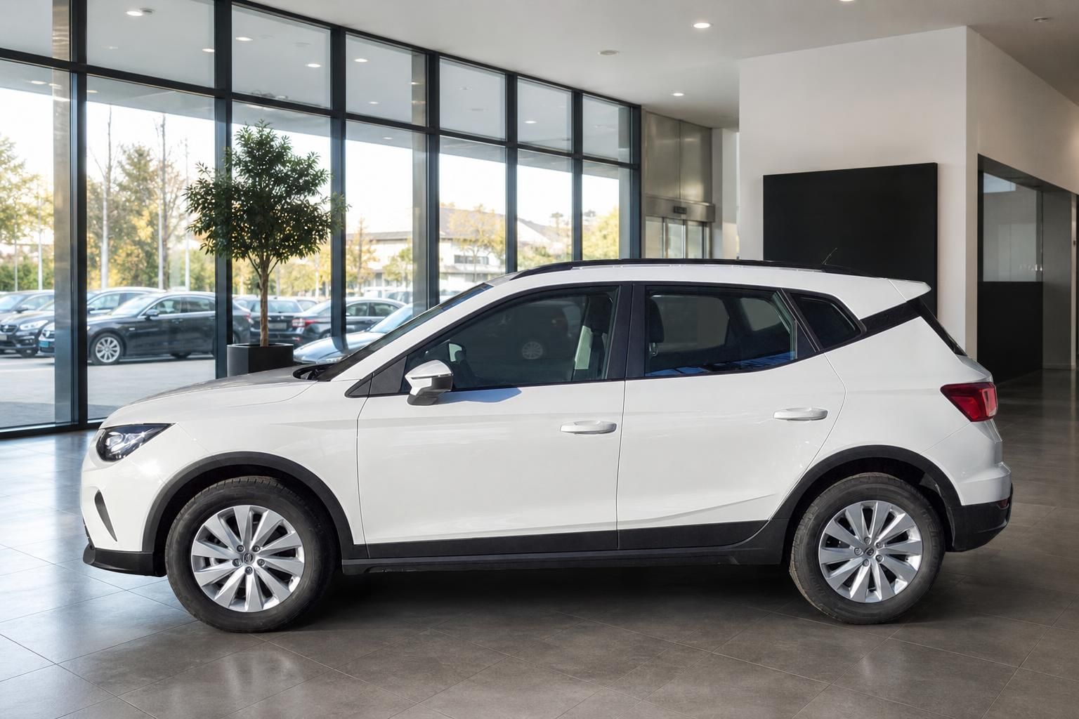 Weißer SEAT Arona in Seitenansicht im modernen Showroom
