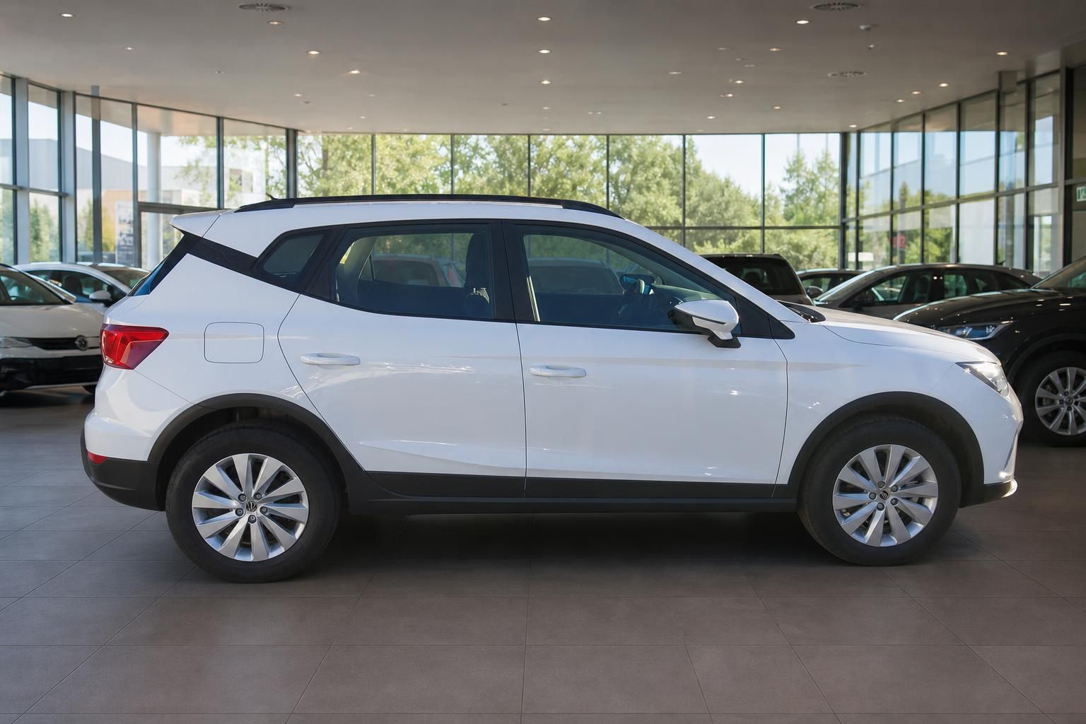 SEAT Arona weiß Seitenprofil im Showroom mit Panoramafenstern