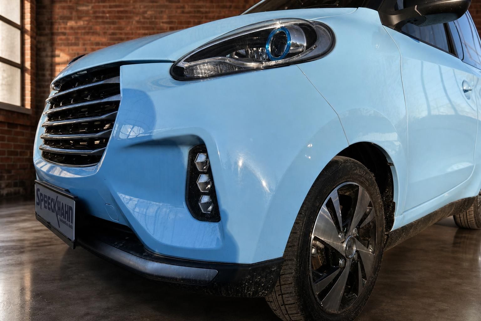 Elaris Elektroauto hellblau – Frontpartie mit LED-Scheinwerfer und Kühlergrill, Händlerschild Speeckhahn