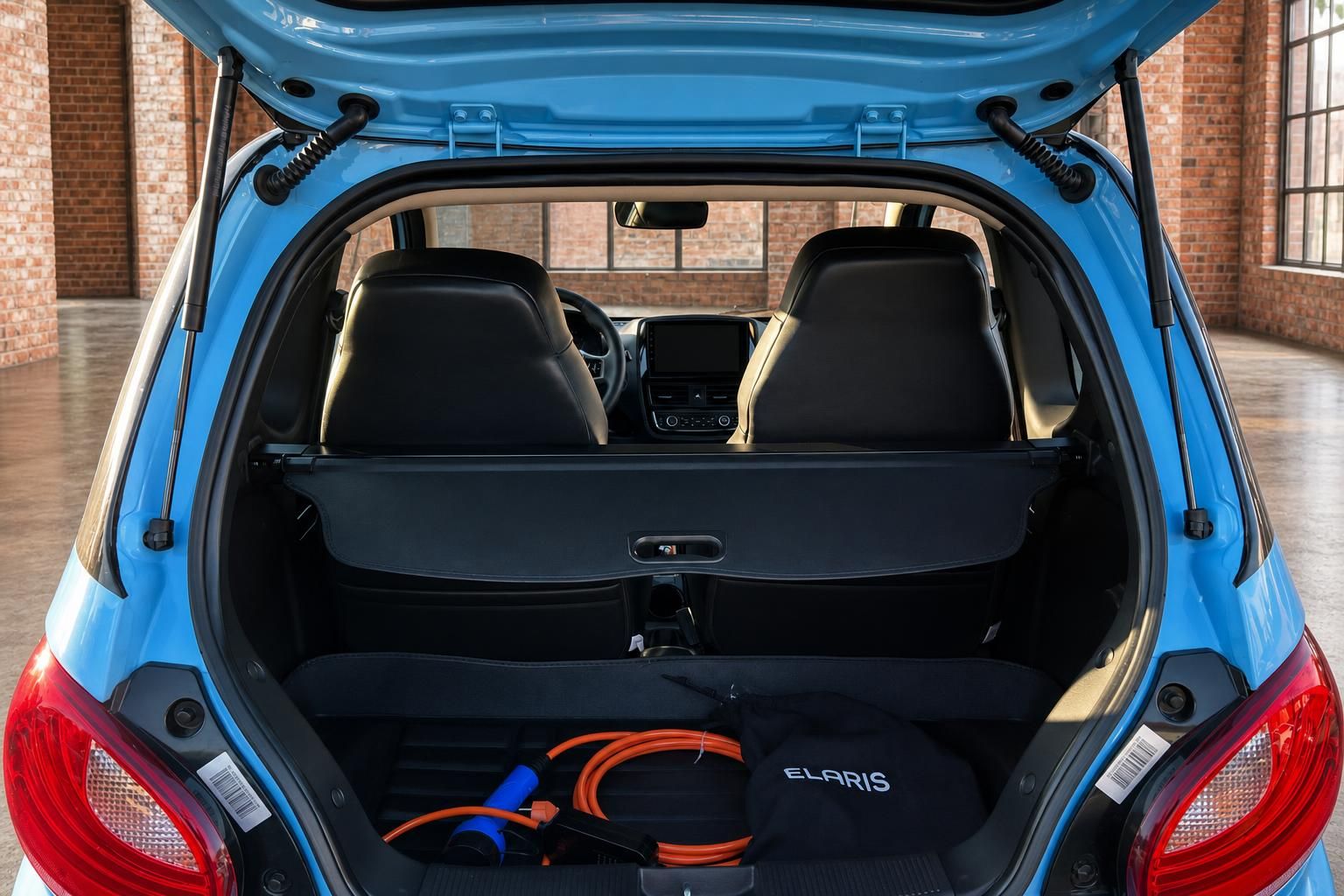 Elaris Elektroauto hellblau – offener Kofferraum mit Ladekabel und Laderaumabdeckung