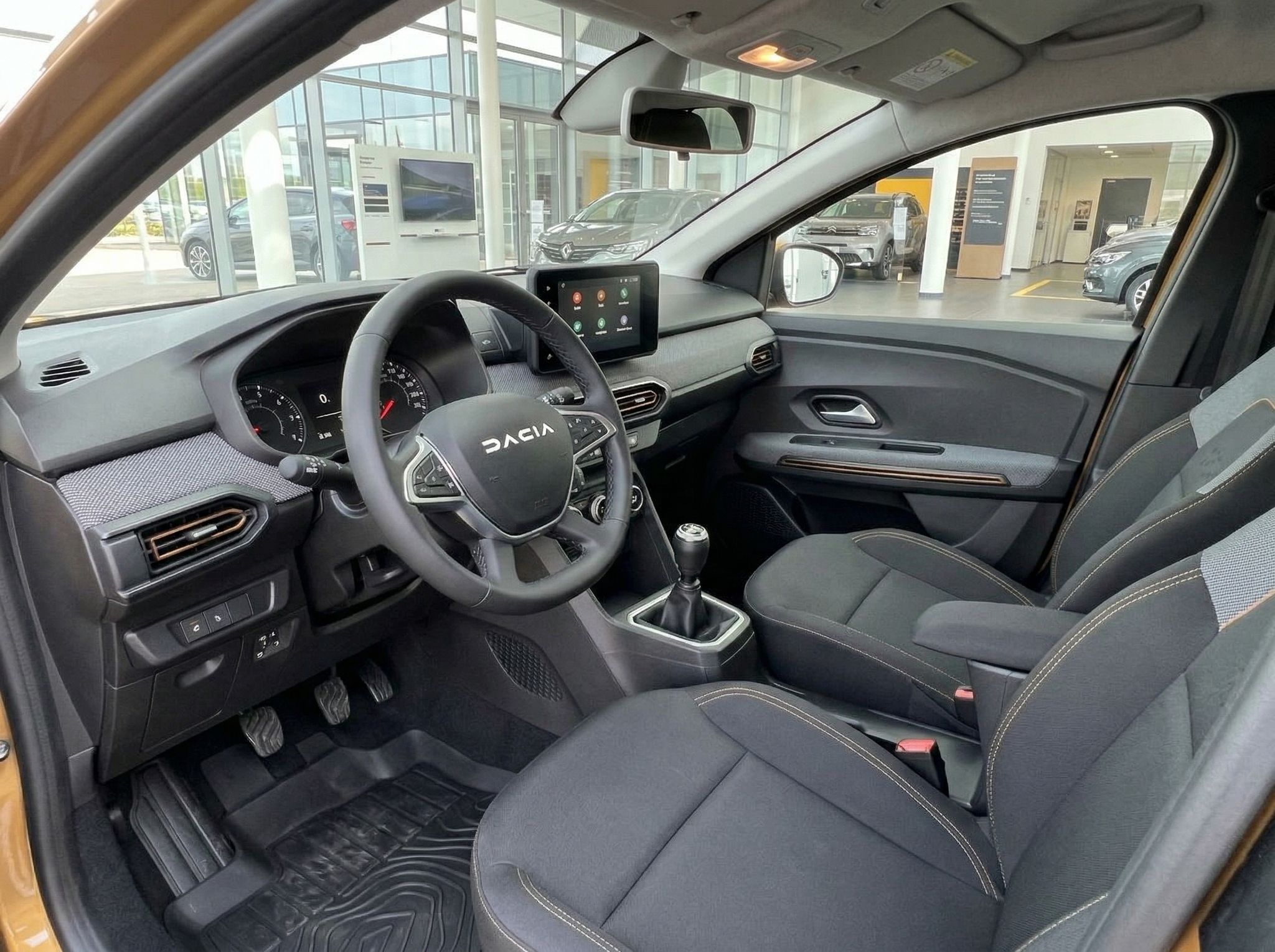 Dacia Innenraum mit schwarzen Sitzen, Lenkrad und Touchscreen-Display - Cockpit Ansicht