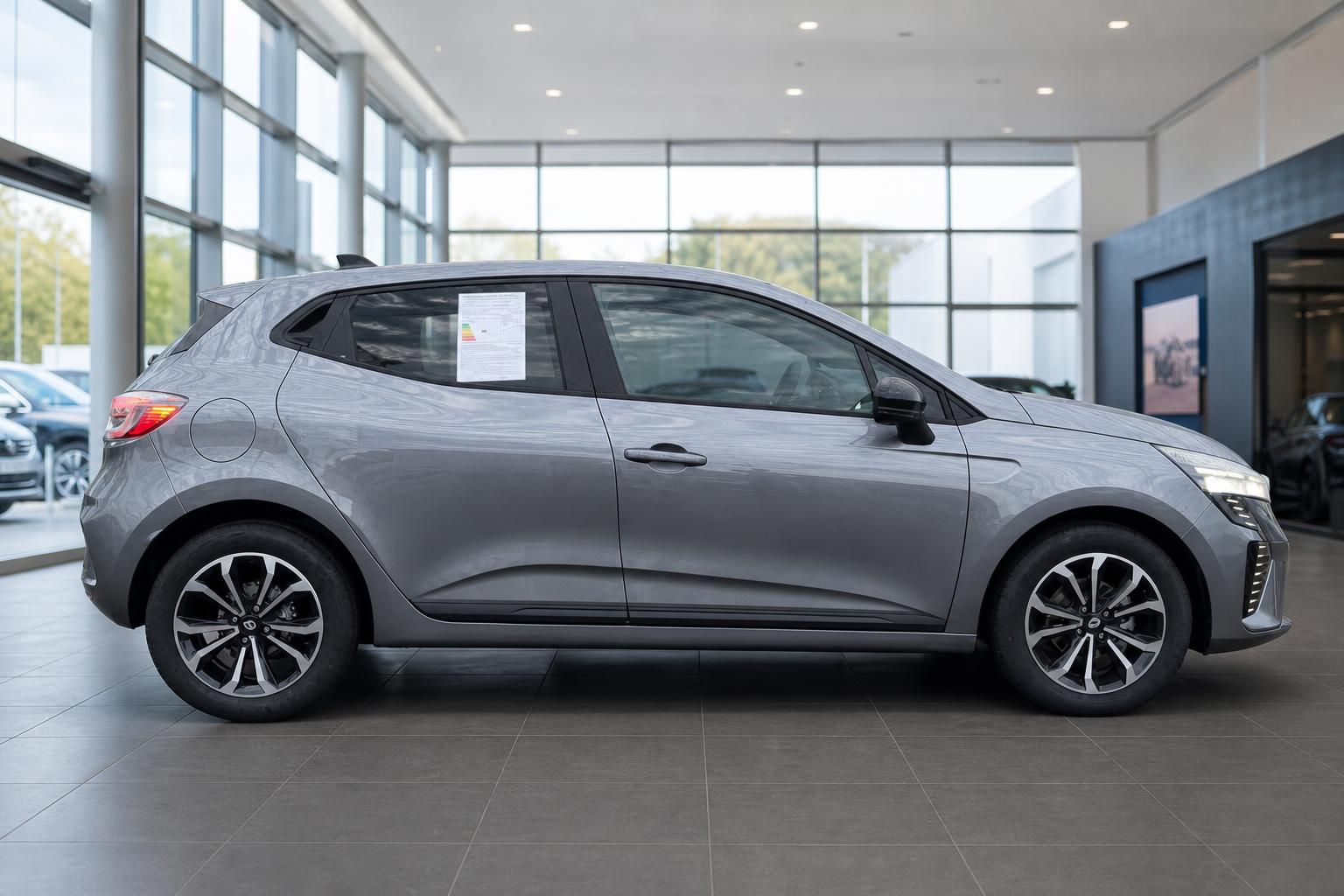 Renault Clio Seitenansicht grau metallic mit Alufelgen im Autohaus