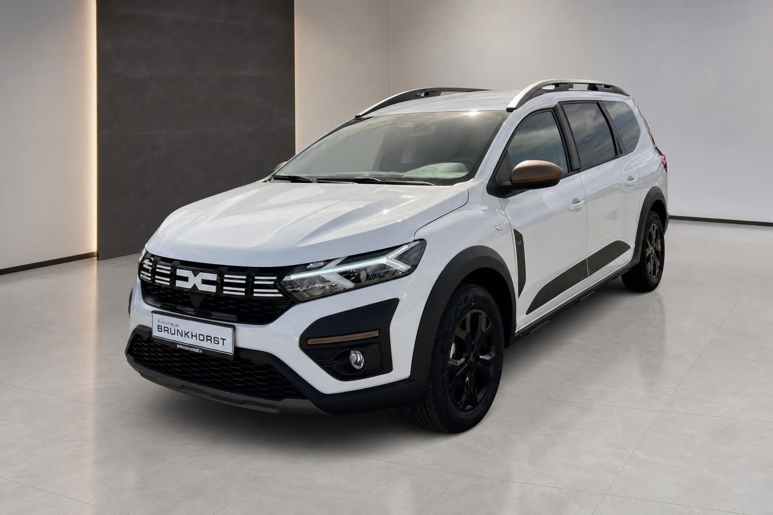Weißer Dacia SUV mit schwarzen Akzenten, Frontansicht im modernen Autohaus Showroom