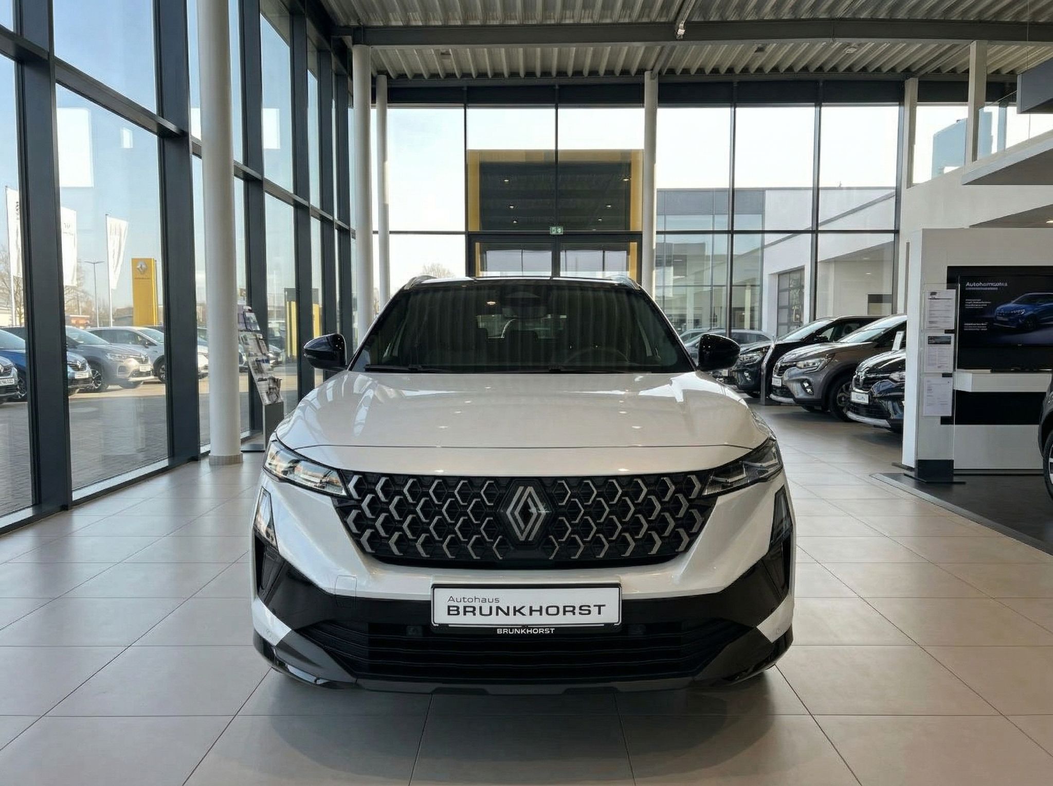 Renault weißer SUV Frontansicht im modernen Autohaus Showroom mit großen Glasfronten