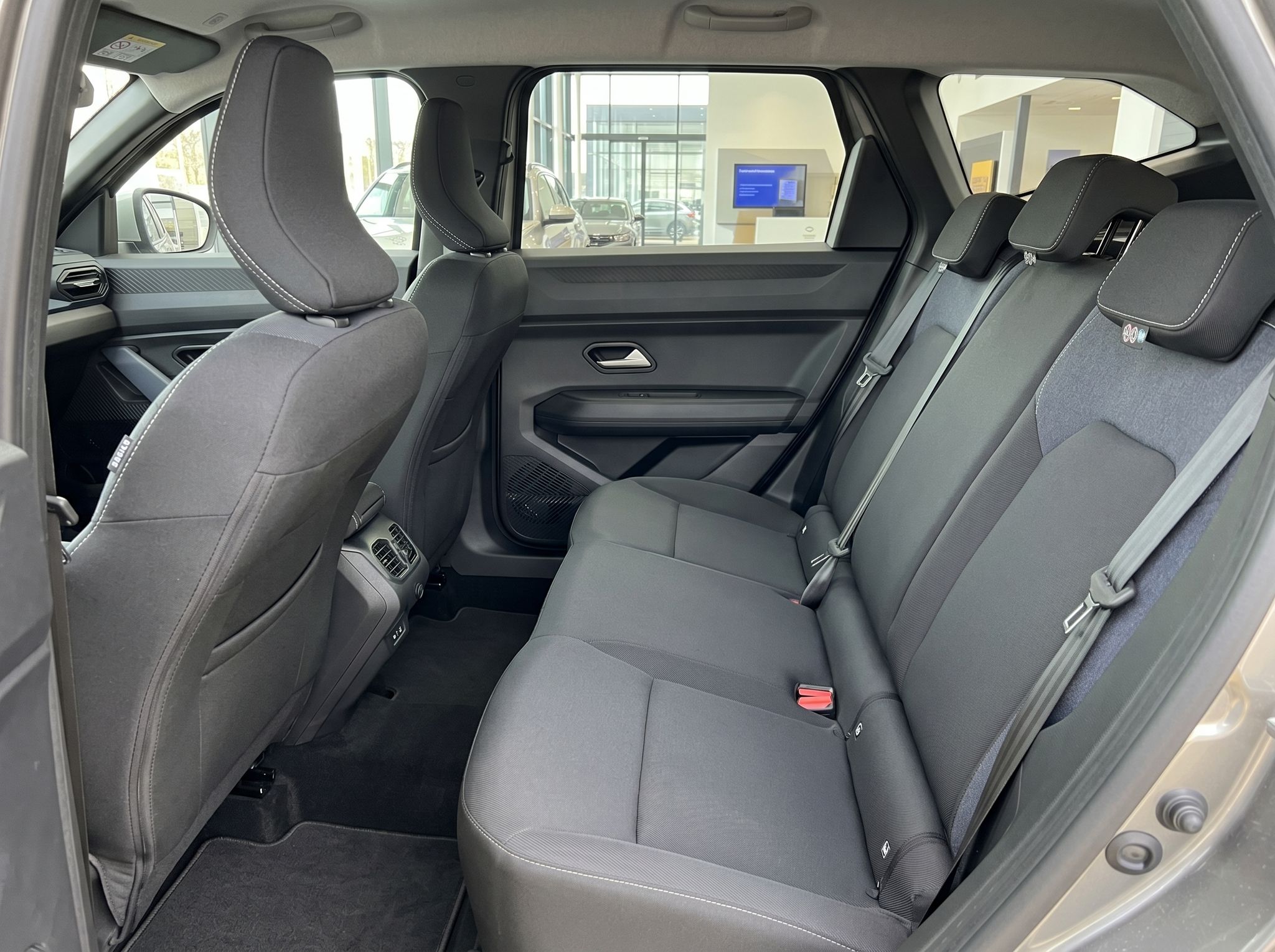 Rückbank mit drei Sitzplätzen und grauer Polsterung im Fahrzeuginnenraum