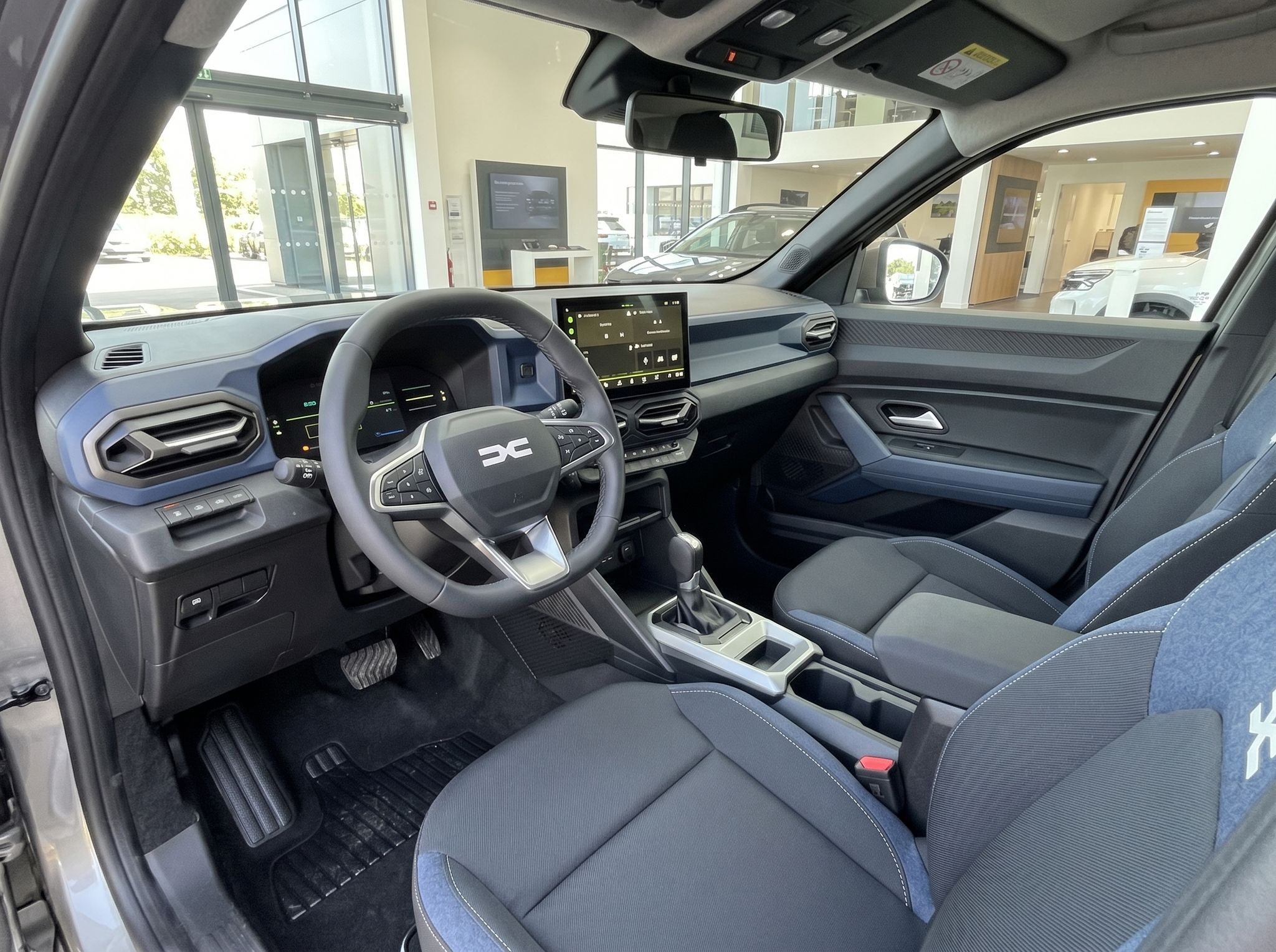 Dacia Innenraum modern - Cockpit mit Touchscreen, Lenkrad und blauen Sitzdetails im SUV