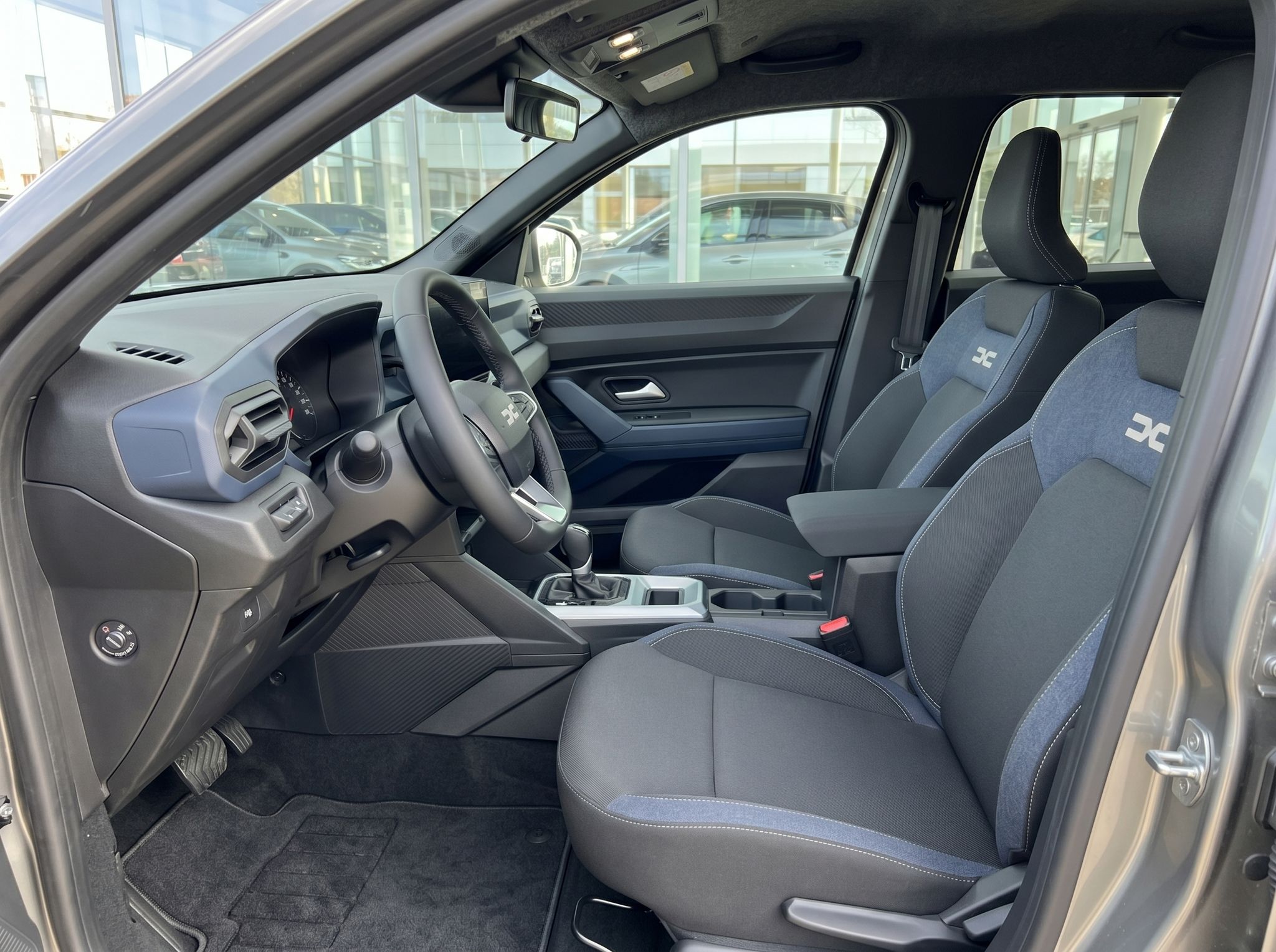 Vordersitze und Fahrerkabine mit grauer Ausstattung und Sicherheitsgurten