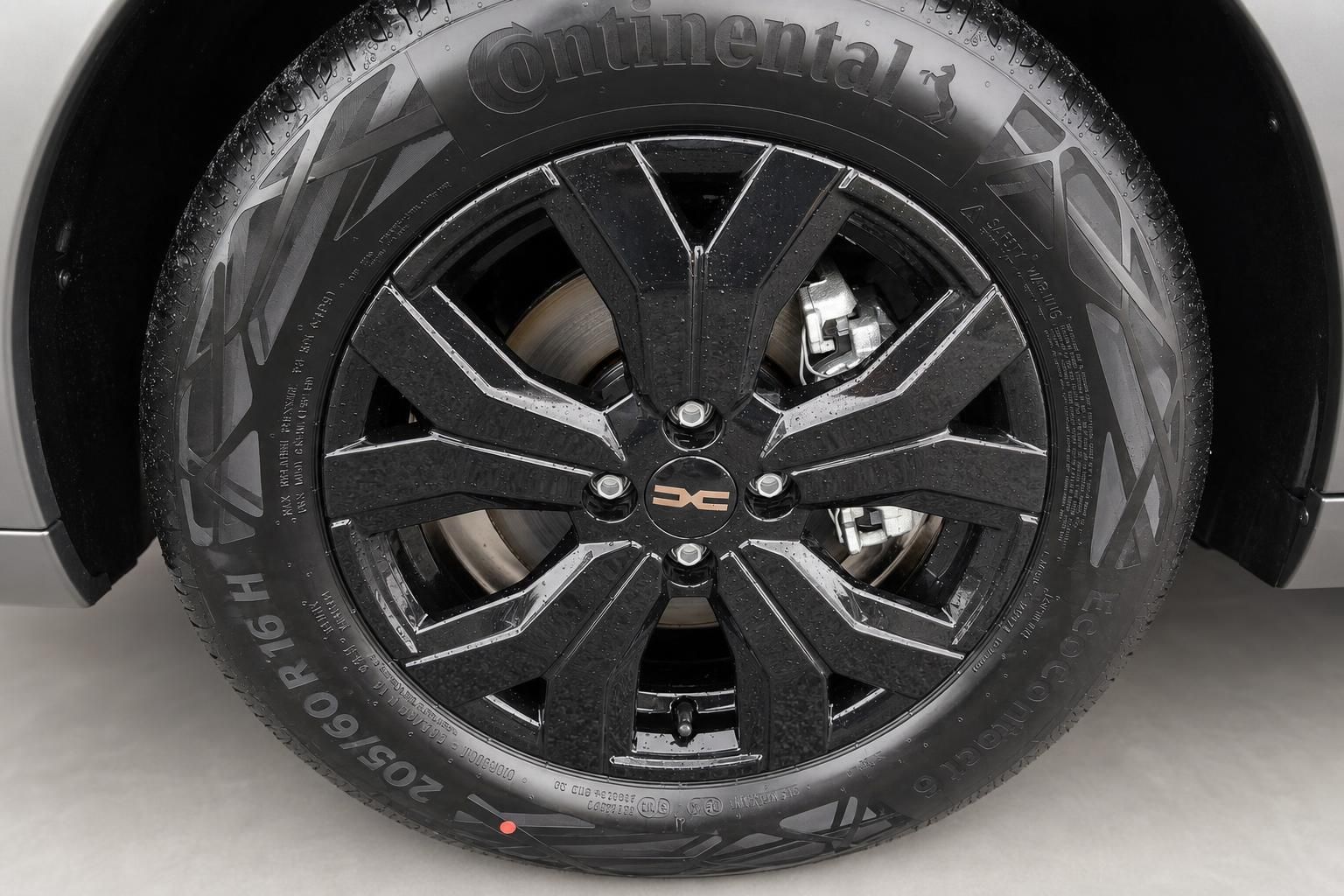 Schwarze Leichtmetallfelge mit modernem Design und Continental-Reifen am Fahrzeug