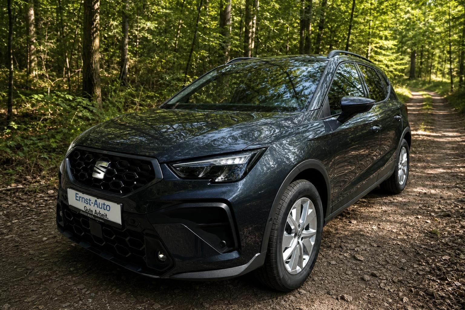 SEAT Arona SUV in dunkelgrau, Frontansicht mit LED-Scheinwerfern in natürlicher Waldkulisse