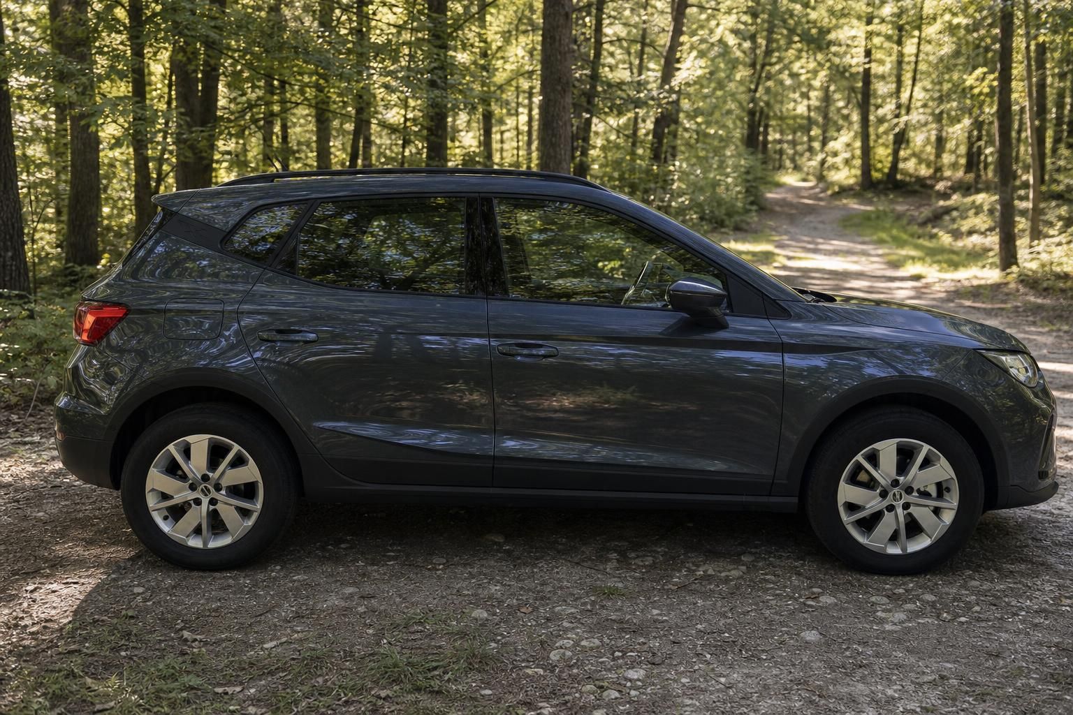 SEAT Arona SUV Seitenansicht rechts, dunkelgraue Karosserie mit Alufelgen auf Waldweg