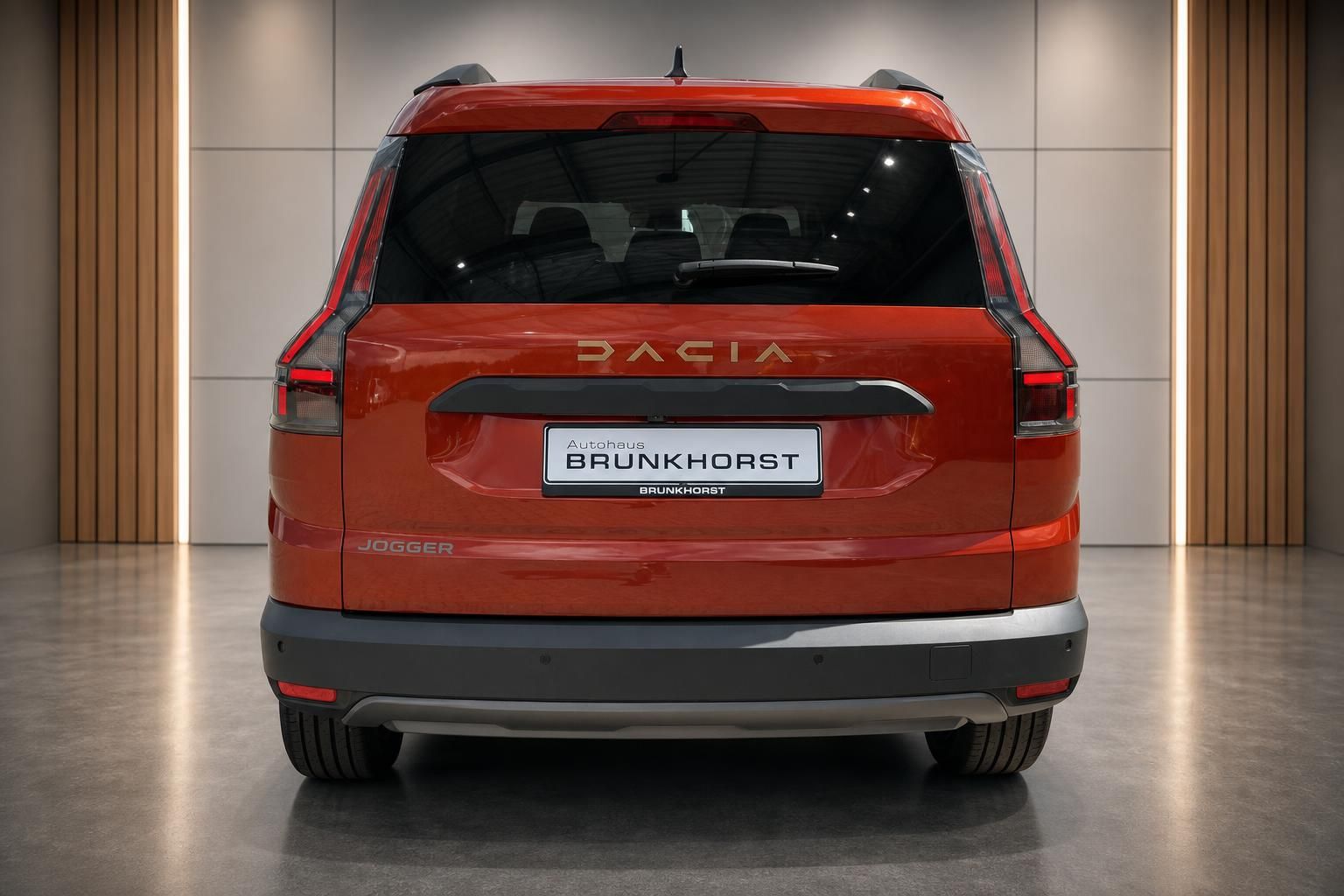 Roter Dacia Jogger Heckansicht mit DACIA Schriftzug und LED-Rücklichtern im Autohaus Showroom
