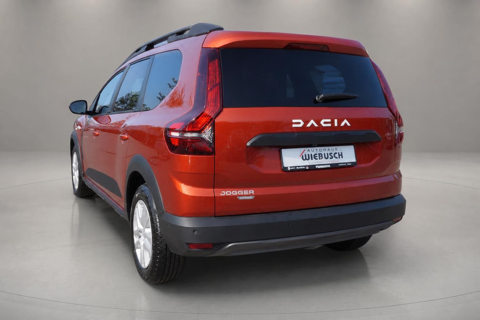 Dacia Jogger Hybrid in Orange Heckansicht schräg links im Autohaus Wiebusch
