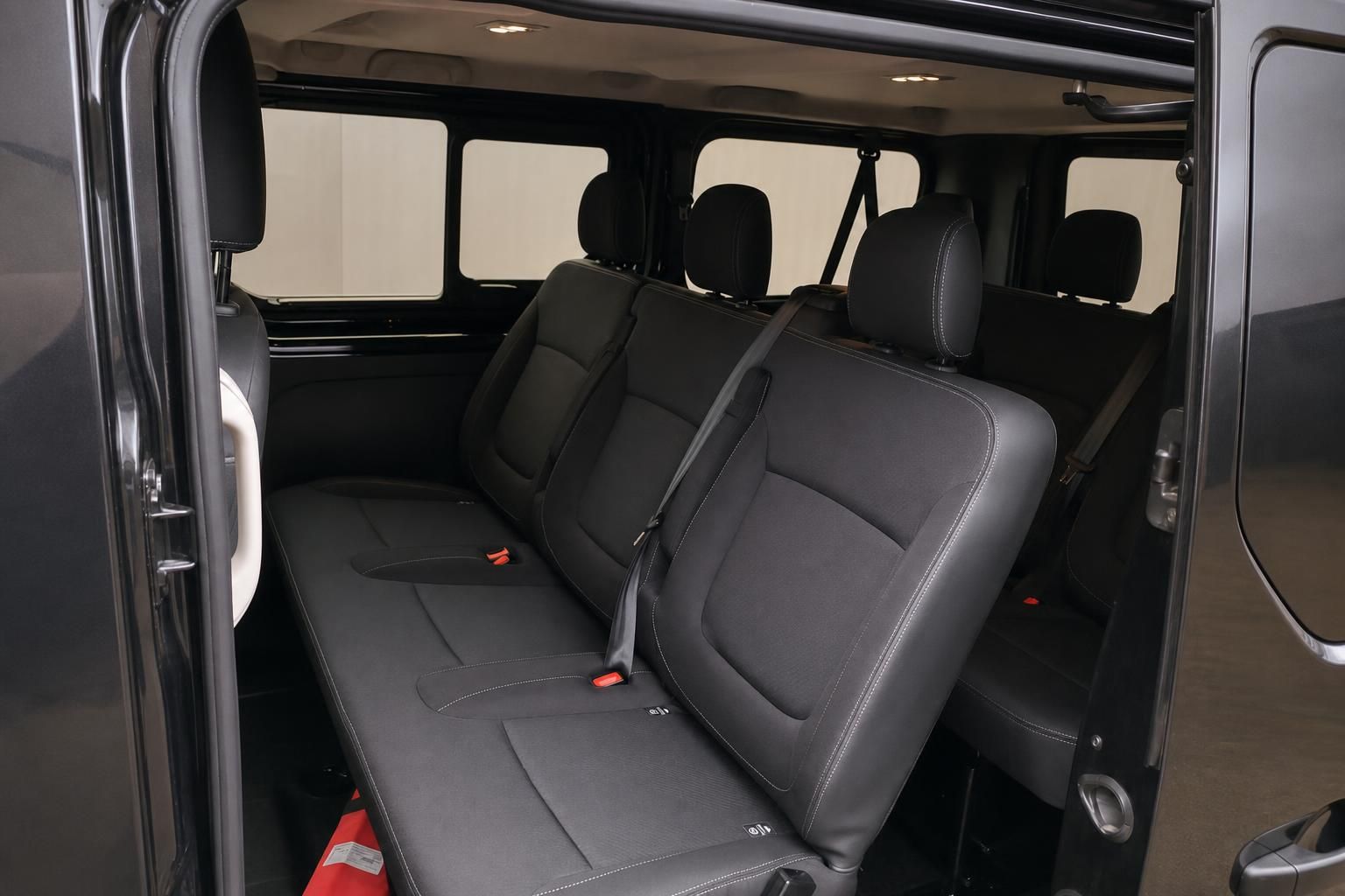 Fahrzeug Fondbereich mit grauen Sitzen und Sicherheitsgurten im Innenraum eines Transporters