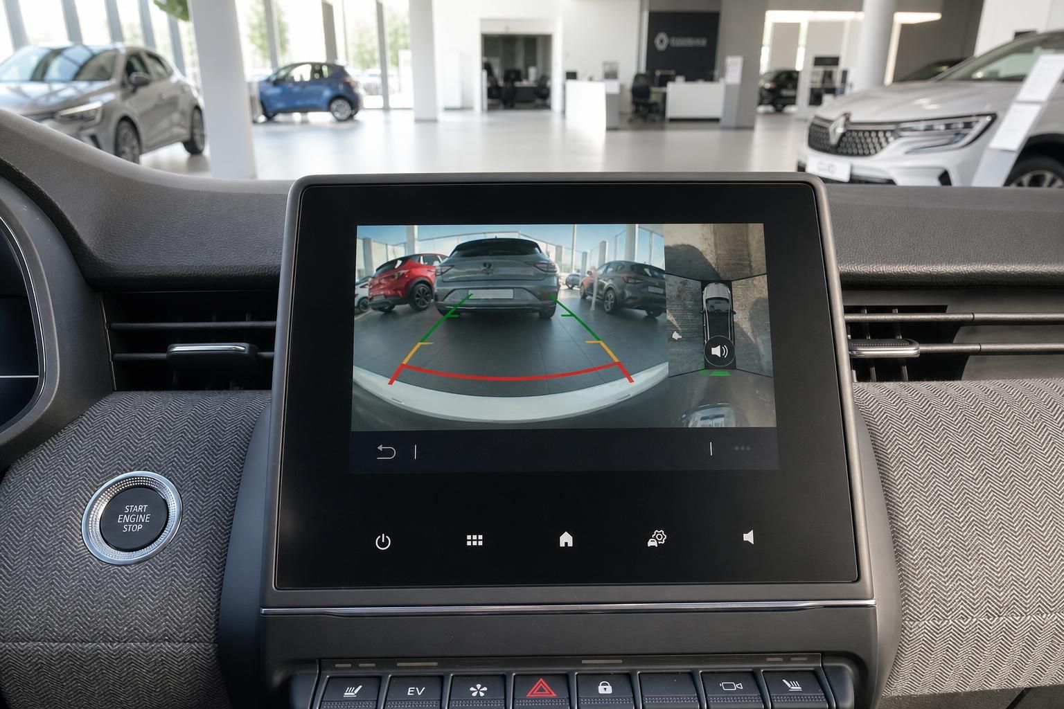 Renault Infotainment-Display mit Rückfahrkamera und Einparkhilfe-Grafik sowie Start-Stopp-Knopf im Autohaus