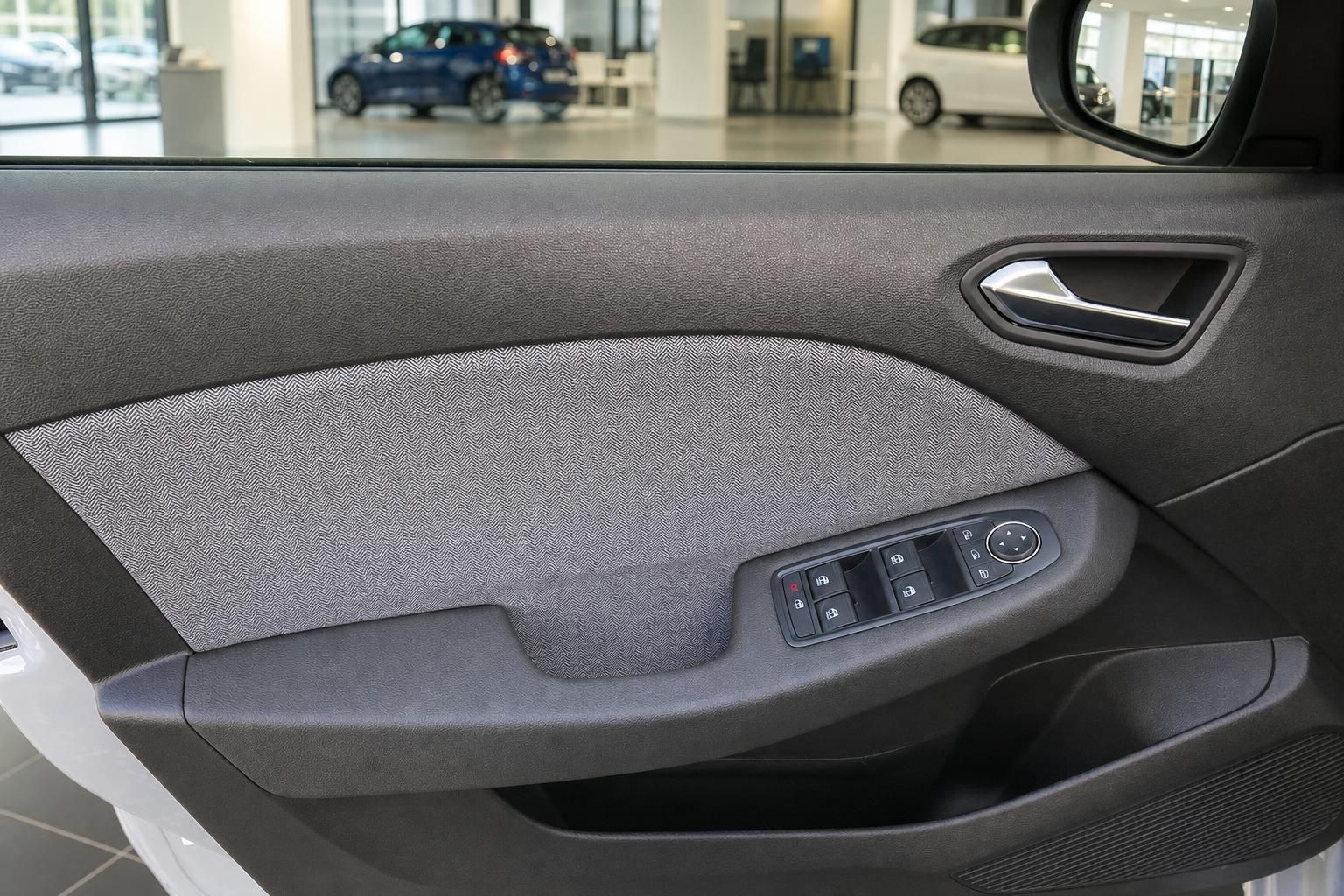 Fahrertür-Innenverkleidung mit Fensterheber-Schaltern und Stoff-Dekor im Autohaus