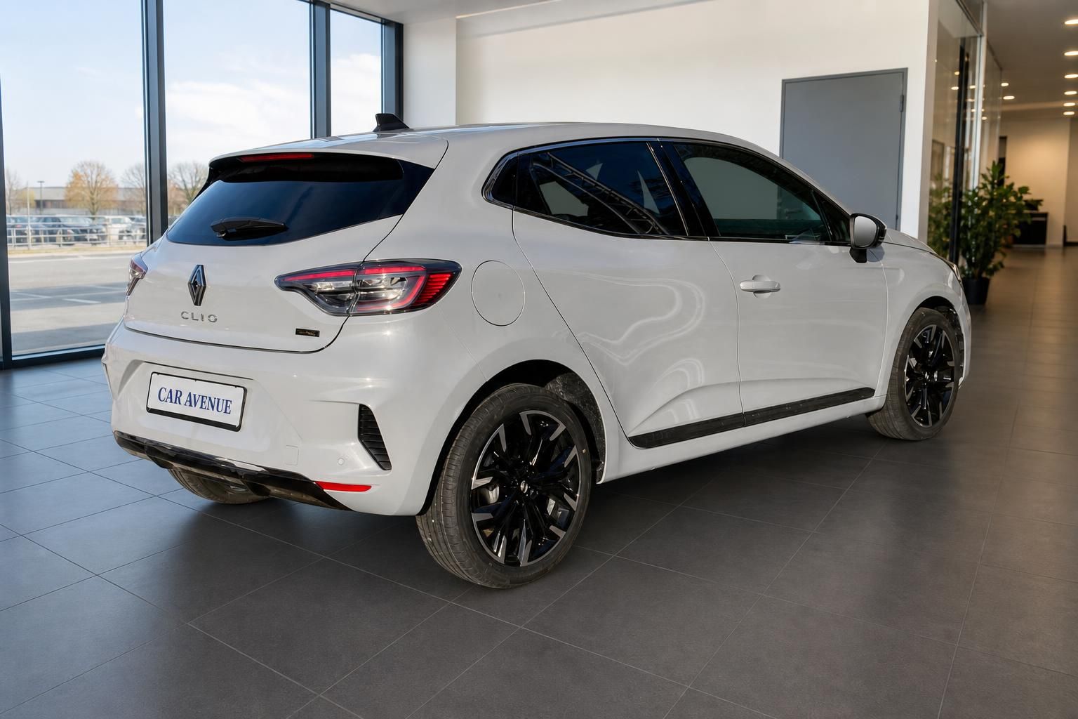 Renault Clio weiß Heckansicht schräg links im Autohaus – sportliche Alufelgen und Dachspoiler