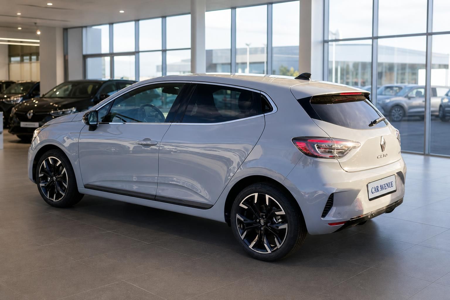 Renault Clio silber Heckansicht schräg rechts im Autohaus – LED-Rückleuchten und schwarze Felgen