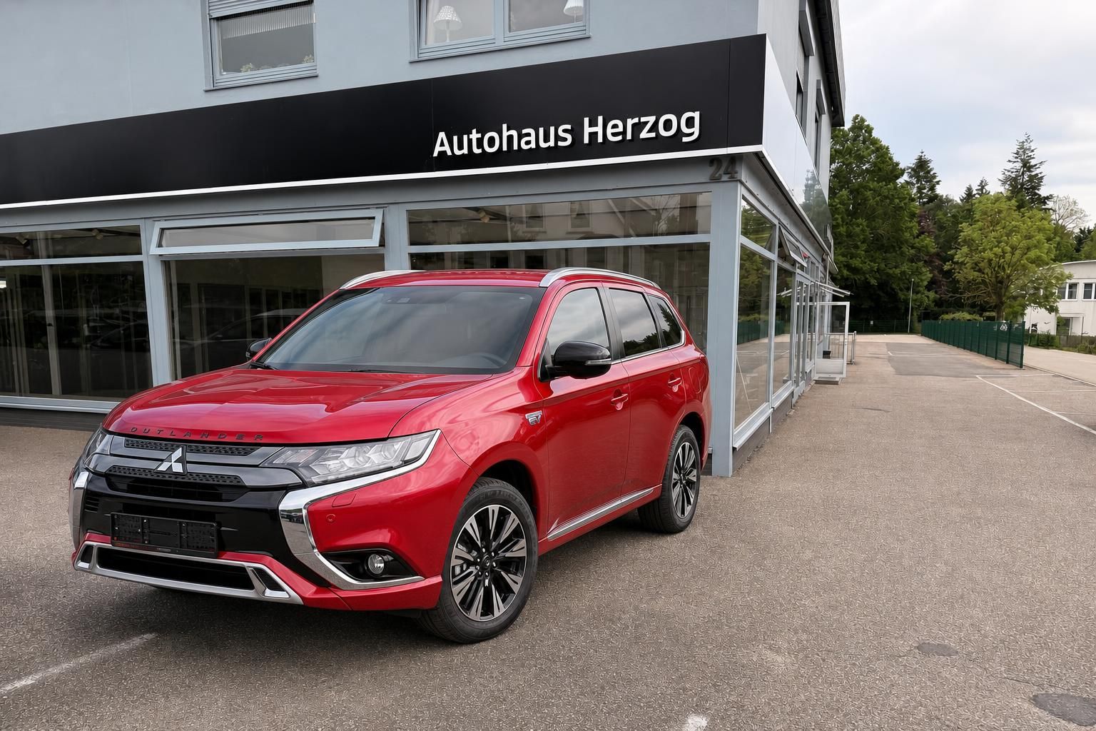 Roter Mitsubishi Outlander SUV vor Autohaus - elegante Frontansicht mit modernem Design