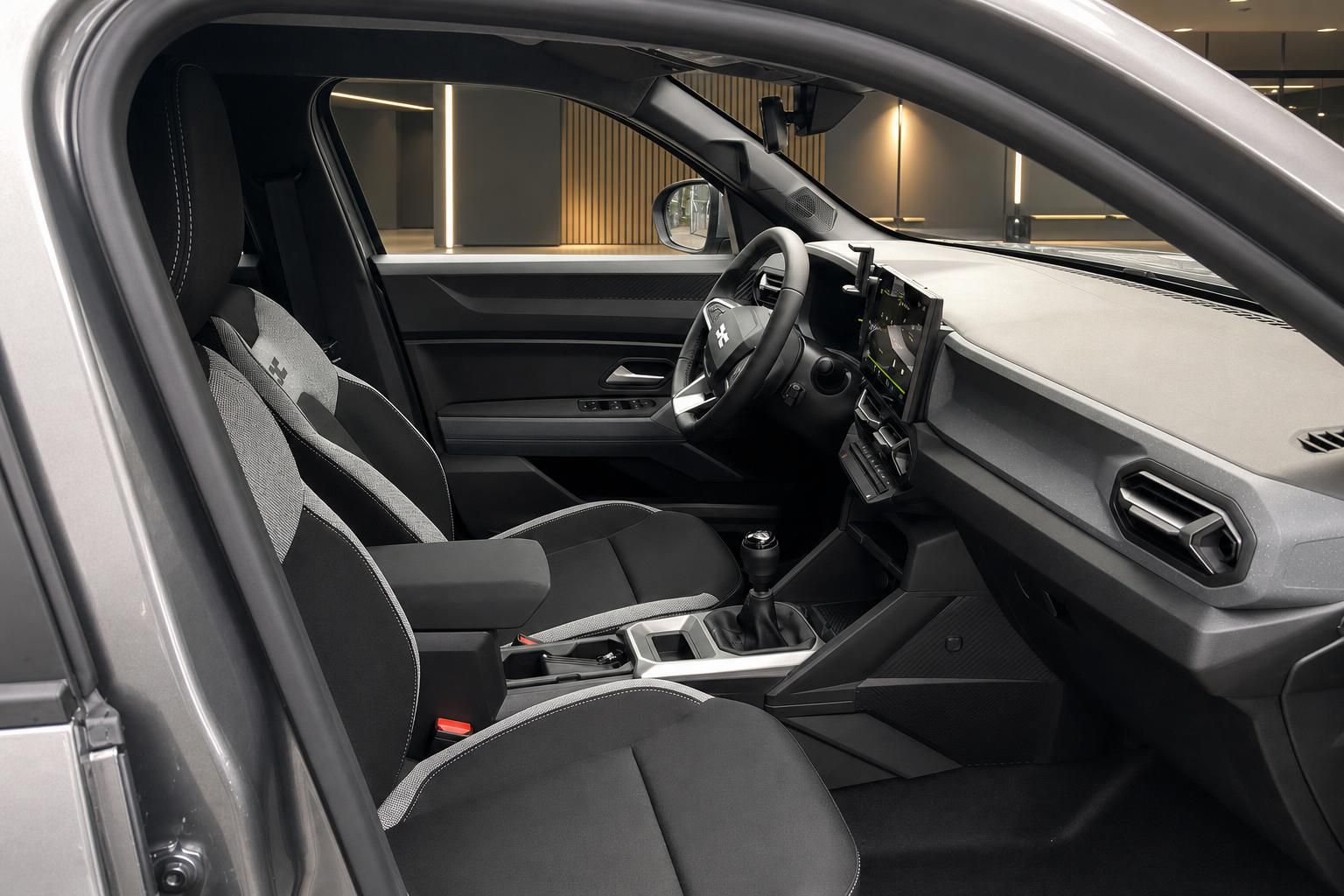 Fahrzeug Innenansicht mit Vordersitzen, Armaturenbrett und Infotainment-System in grauer Ausstattung