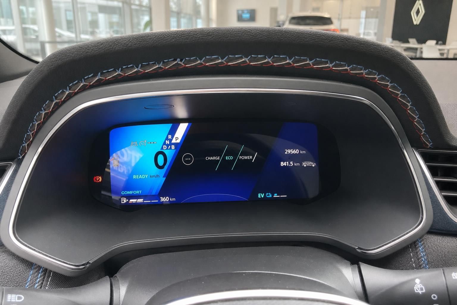Digitales Armaturenbrett mit blauem Display zeigt Elektrofahrzeug-Informationen und Reichweite