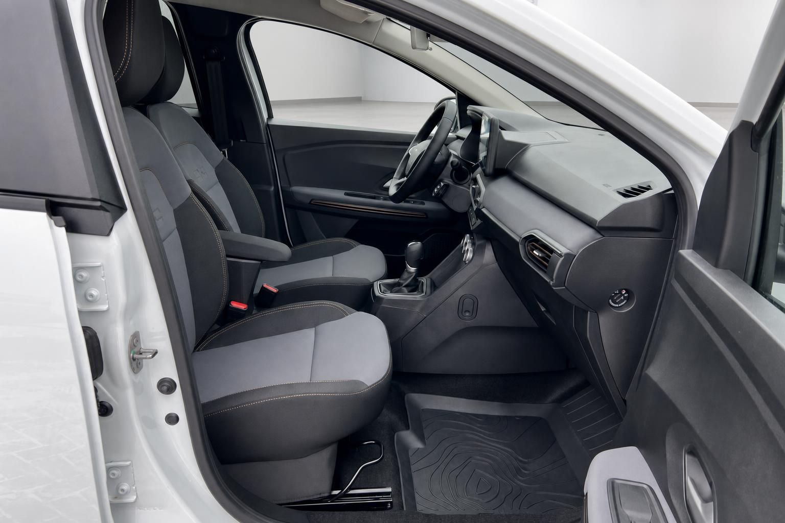 Dacia Innenraum Beifahrerseite mit grauen Sitzen und Schaltgetriebe
