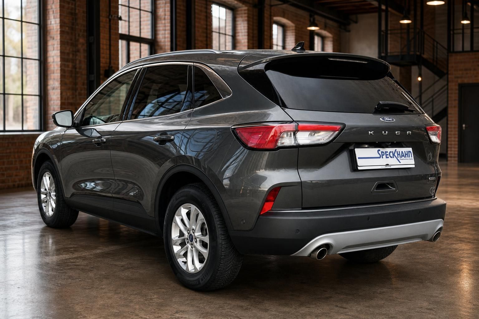 Ford Kuga in Grau, Heckansicht schräg in Loft-Halle