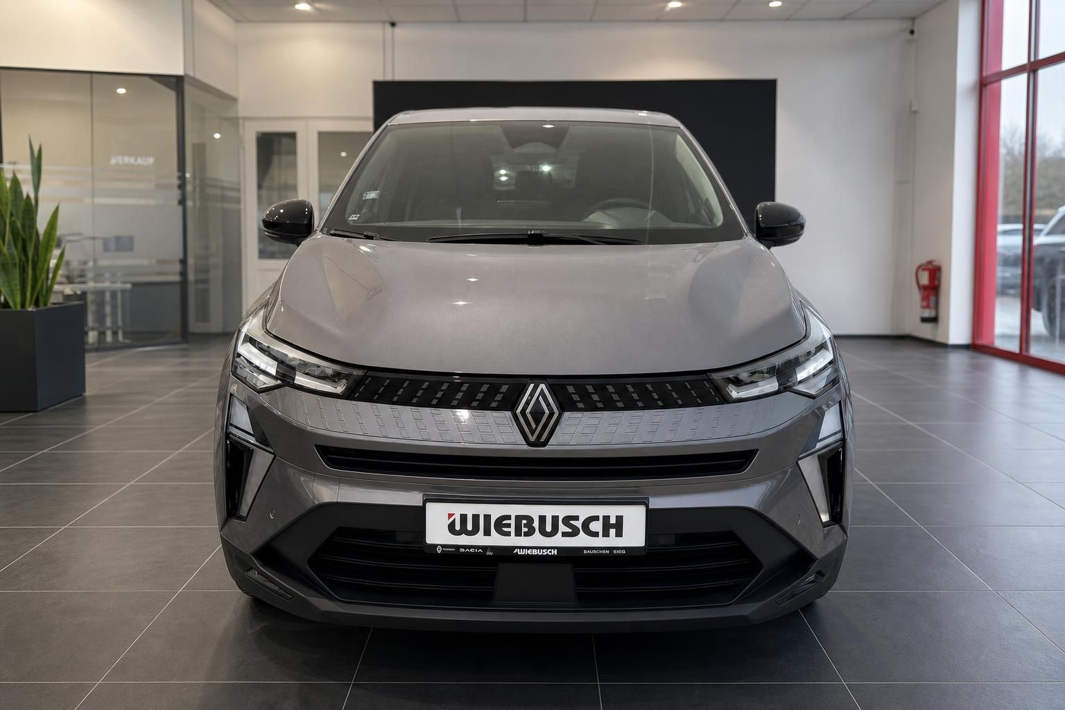 Grauer Renault Captur Frontansicht mit modernem LED-Design und Händlerkennzeichen